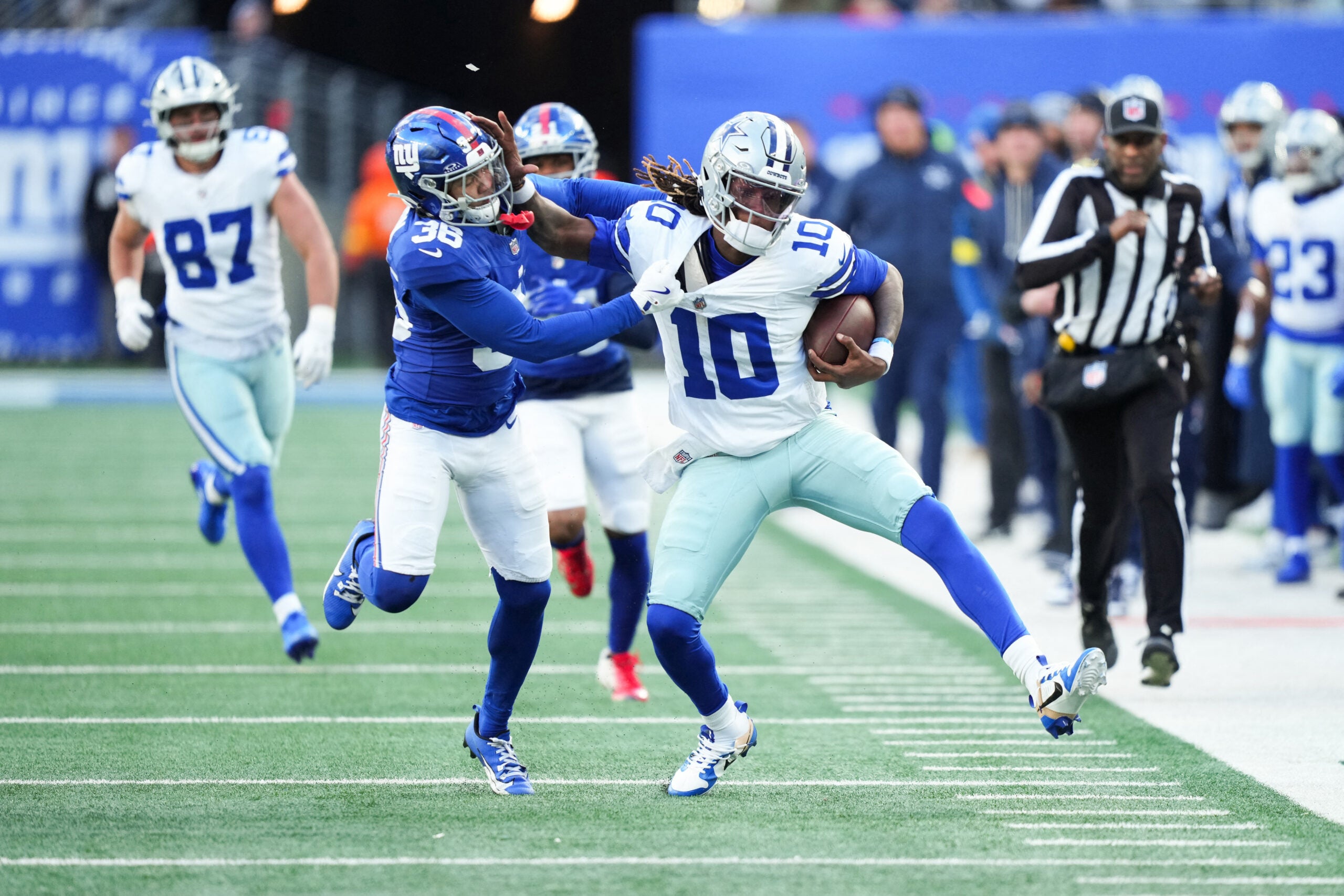 Jan 4, 2026; East Rutherford, New Jersey, USA; Dallas Cowboys quarterback Joe Milton III (10) scrambles and is tackled by New York Giants cornerback Rico Payton (36) during the fourth quarter at MetLife Stadium.
