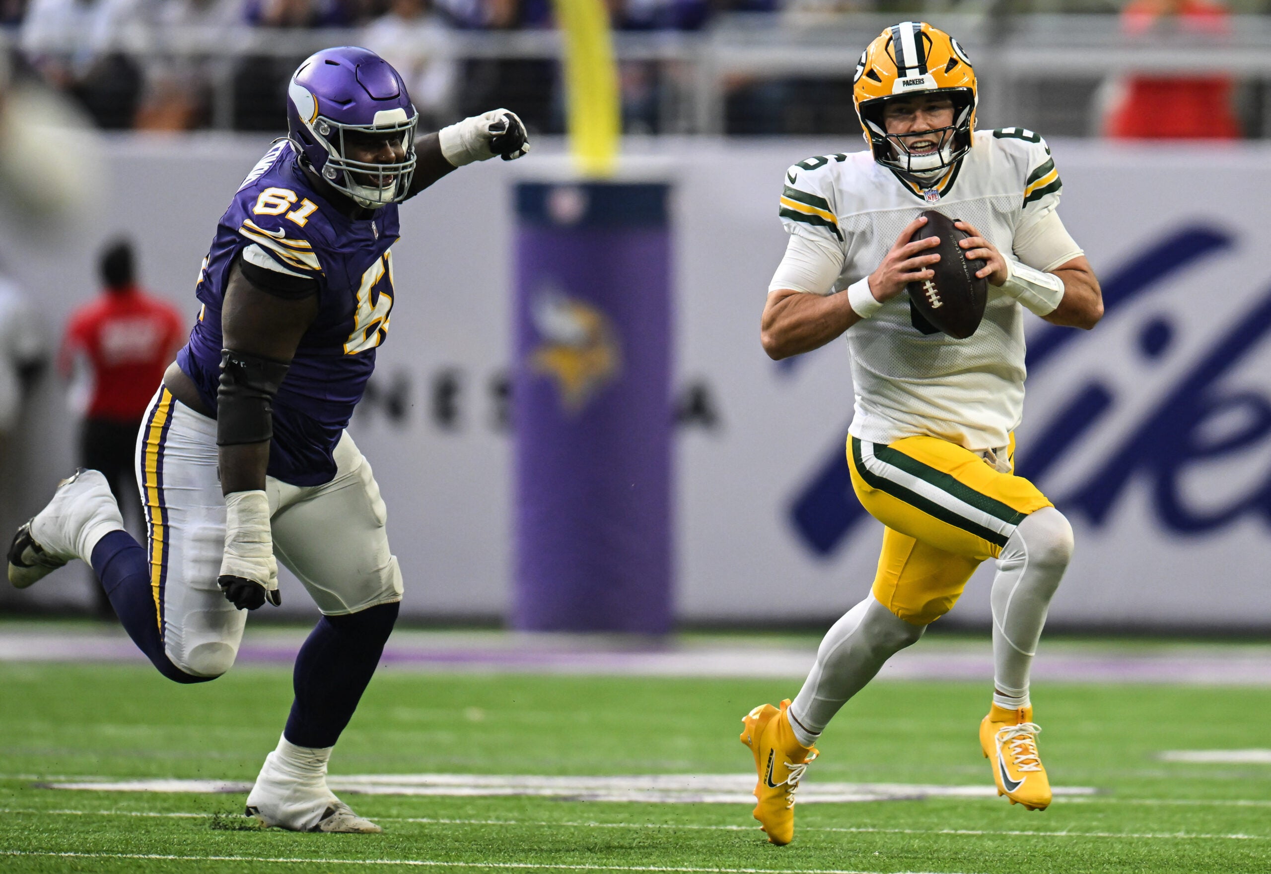 Jan 4, 2026; Minneapolis, Minnesota, USA; Green Bay Packers quarterback Clayton Tune (6) runs the ball past Minnesota Vikings defensive tackle Jalen Redmond (61) during the third quarter at U.S. Bank Stadium.