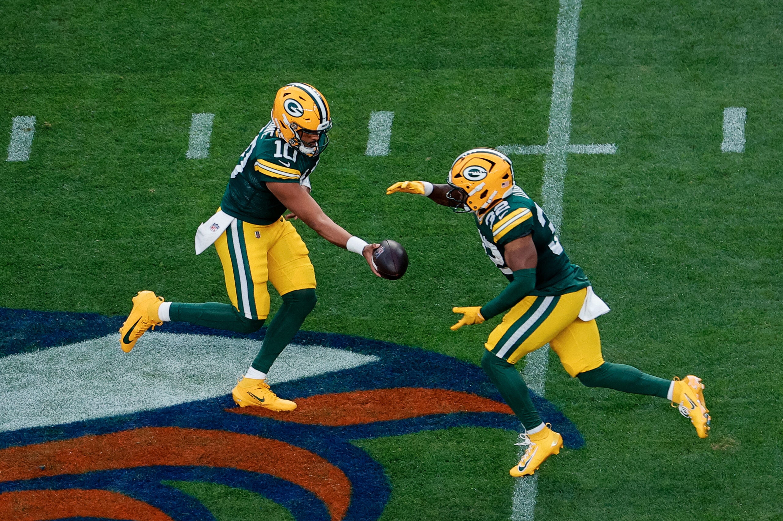 Aug 21, 2026; Denver, Colorado, USA; Green Bay Packers quarterback Jordan Love (10) hands the ball off to running back Marshawn Lloyd (32) in the first quarter against the Denver Broncos at Empower Field at Mile High.