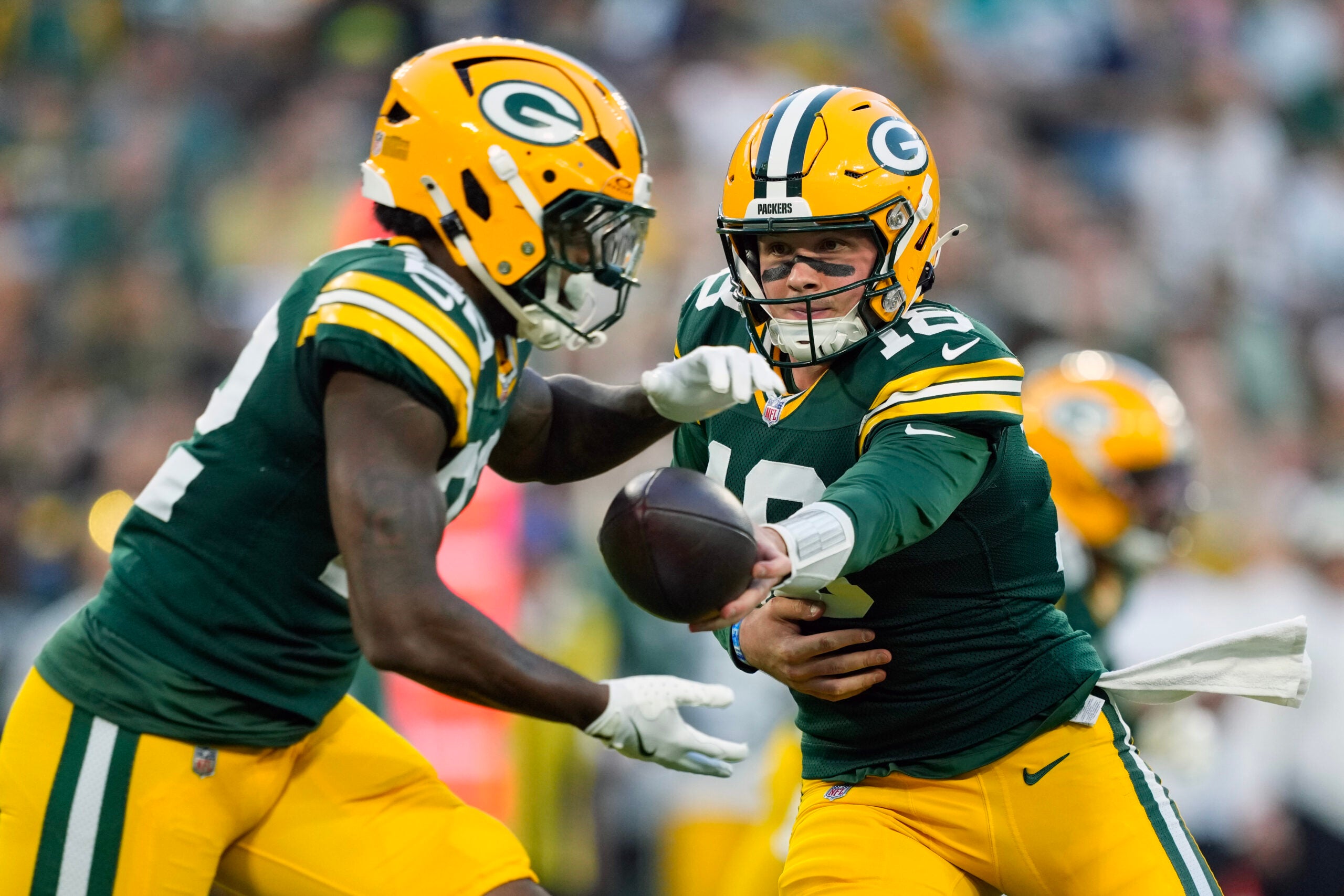 Aug 28, 2026; Green Bay, Wisconsin, USA; Green Bay Packers quarterback Kyle McCord (18) hands the football off to running back Pierre Strong Jr. (22) during the first quarter against the Arizona Cardinals at Lambeau Field.