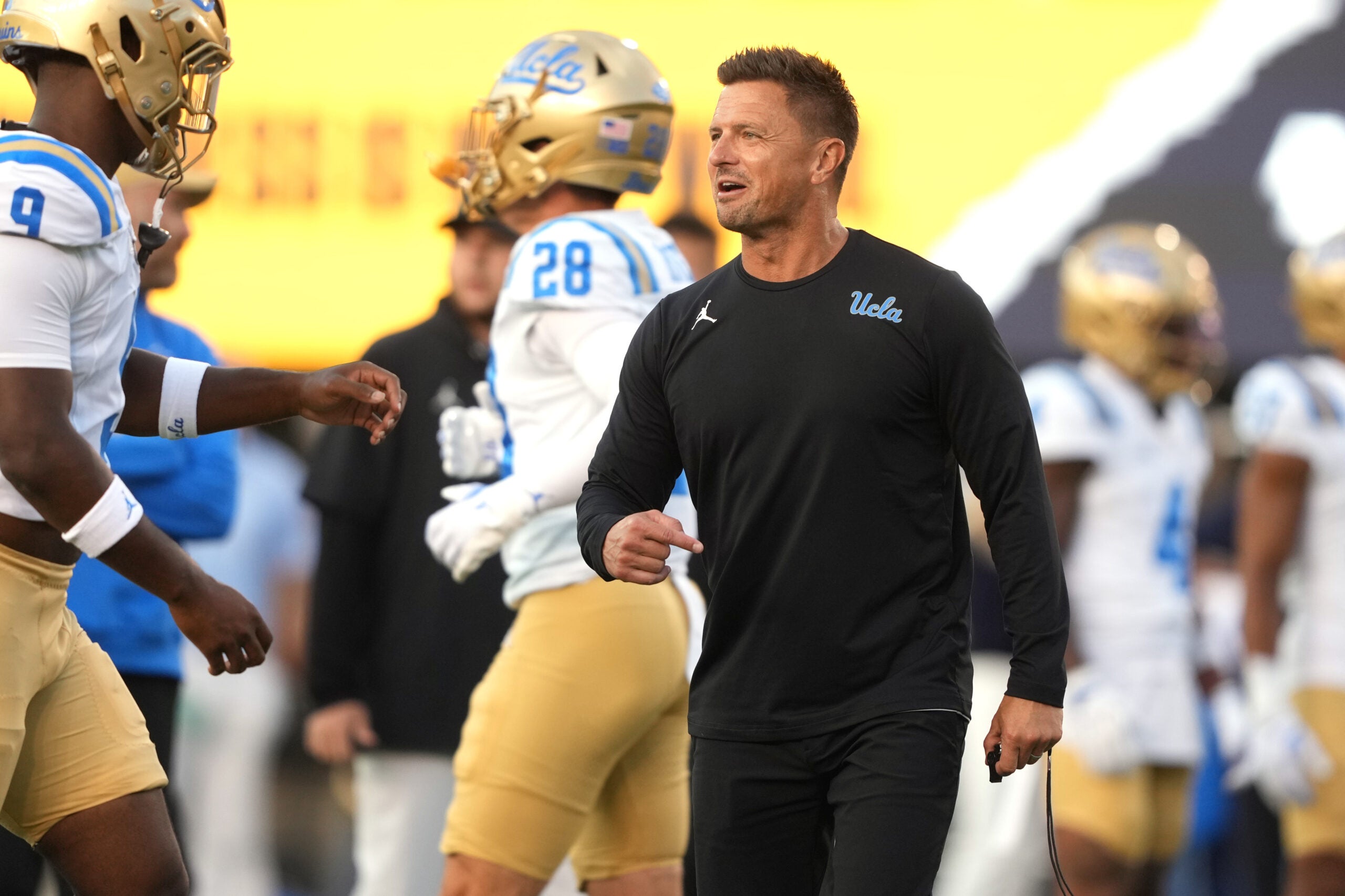 Sep 5, 2026; Berkeley, California, USA; UCLA Bruins head coach Bob Chesney (center) talks to UCLA Bruins linebacker Jalen Woods (left) before the game against the California Golden Bears at California Memorial Stadium.
