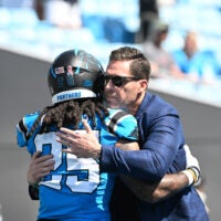 Sep 13, 2026; Charlotte, North Carolina, USA; Carolina Panthers general manager Dan Morgan (right) greets running back Jonathon Brooks (25) before the game against the Chicago Bears at Bank of America Stadium.