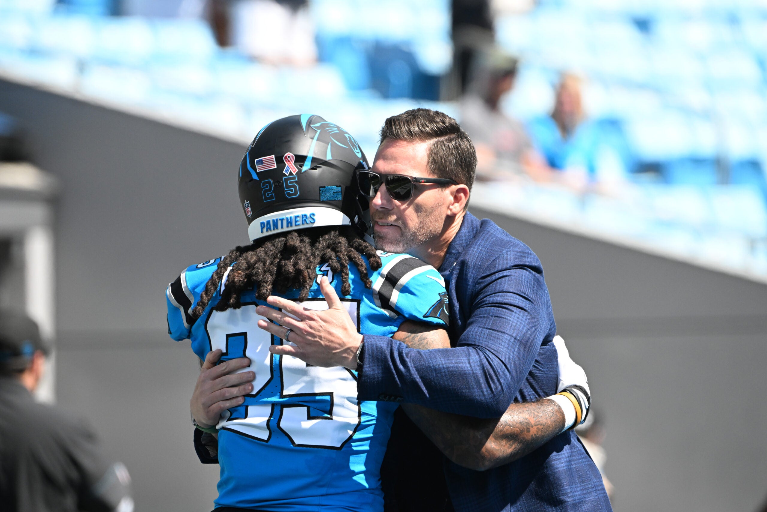 Sep 13, 2026; Charlotte, North Carolina, USA; Carolina Panthers general manager Dan Morgan (right) greets running back Jonathon Brooks (25) before the game against the Chicago Bears at Bank of America Stadium.