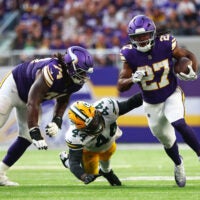 Sep 13, 2026; Minneapolis, Minnesota, USA; Minnesota Vikings running back Jordan Mason (27) runs the ball against Green Bay Packers linebacker Zaire Franklin (44) during the second half at U.S. Bank Stadium.
