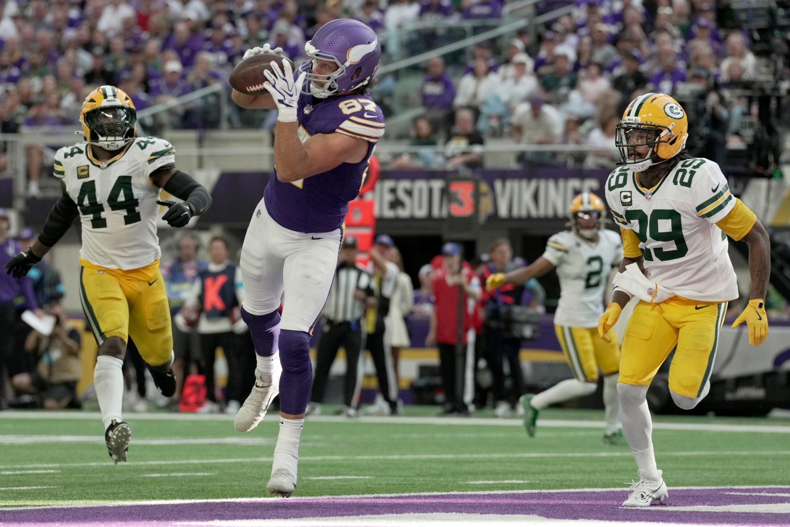 Minnesota Vikings tight end T.J. Hockenson (87) catches a touchdown pass between Green Bay Packers linebacker Zaire Franklin (44) and safety Xavier McKinney (29) during the third quarter of their game Sunday, Sept. 13, 2026 at U.S. Bank Stadium in Minneapolis, Minnesota. The Minnesota Vikings beat the Green Bay Packers 39-22.