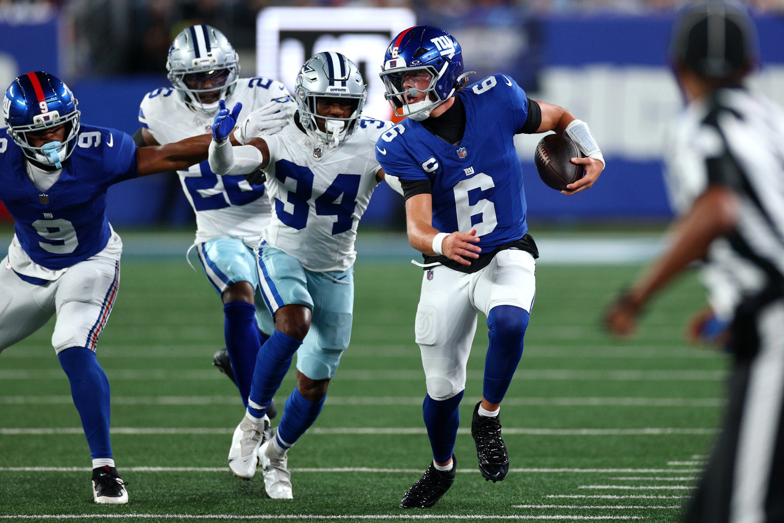 Sep 13, 2026; East Rutherford, New Jersey, USA; New York Giants quarterback Jaxson Dart (6) scrambles with the ball defended by Dallas Cowboys safety Jalen Thompson (34) during the first quarter at MetLife Stadium.