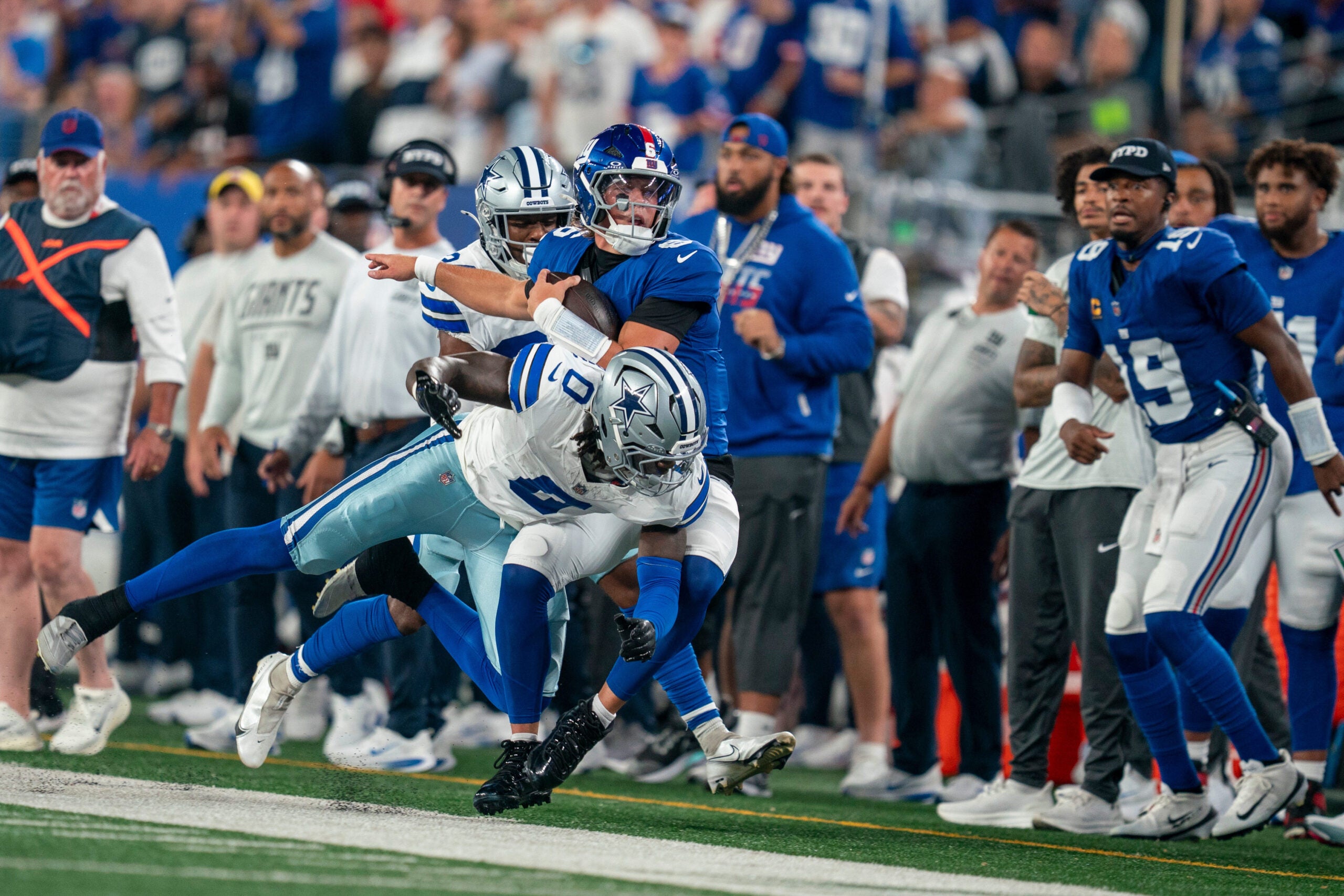 New York Giants quarterback Jaxson Dart (6) is hit out of bounds by Dallas Cowboys linebacker DeMarvion Overshown (0) during a week one opening game between the New York Giants and Dallas Cowboys at Metlife Stadium on Sunday, Sept. 13, 2026, in East Rutherford, NJ.