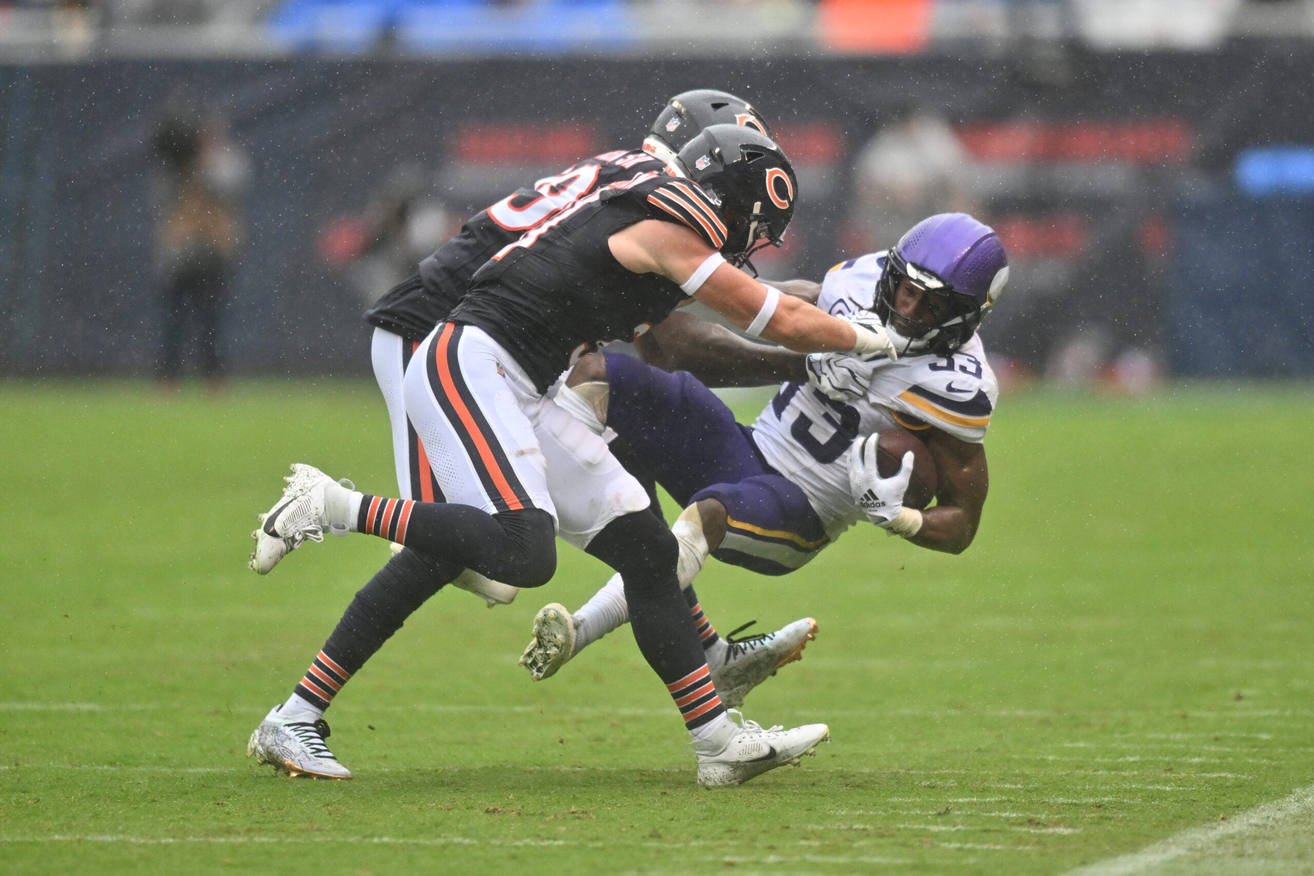 Sep 20, 2026; Chicago, Illinois, USA; Minnesota Vikings running back Aaron Jones Sr. (33) is tacked by Chicago Bears cornerback Tyrique Stevenson (29) and safety Dillon Thieneman (31) during the first half at Soldier Field.