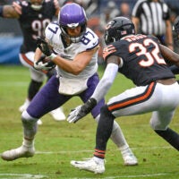 Sep 20, 2026; Chicago, Illinois, USA; Minnesota Vikings tight end T.J. Hockenson (87) runs against Chicago Bears defensive back Xavier Woods (32) during the second half at Soldier Field.