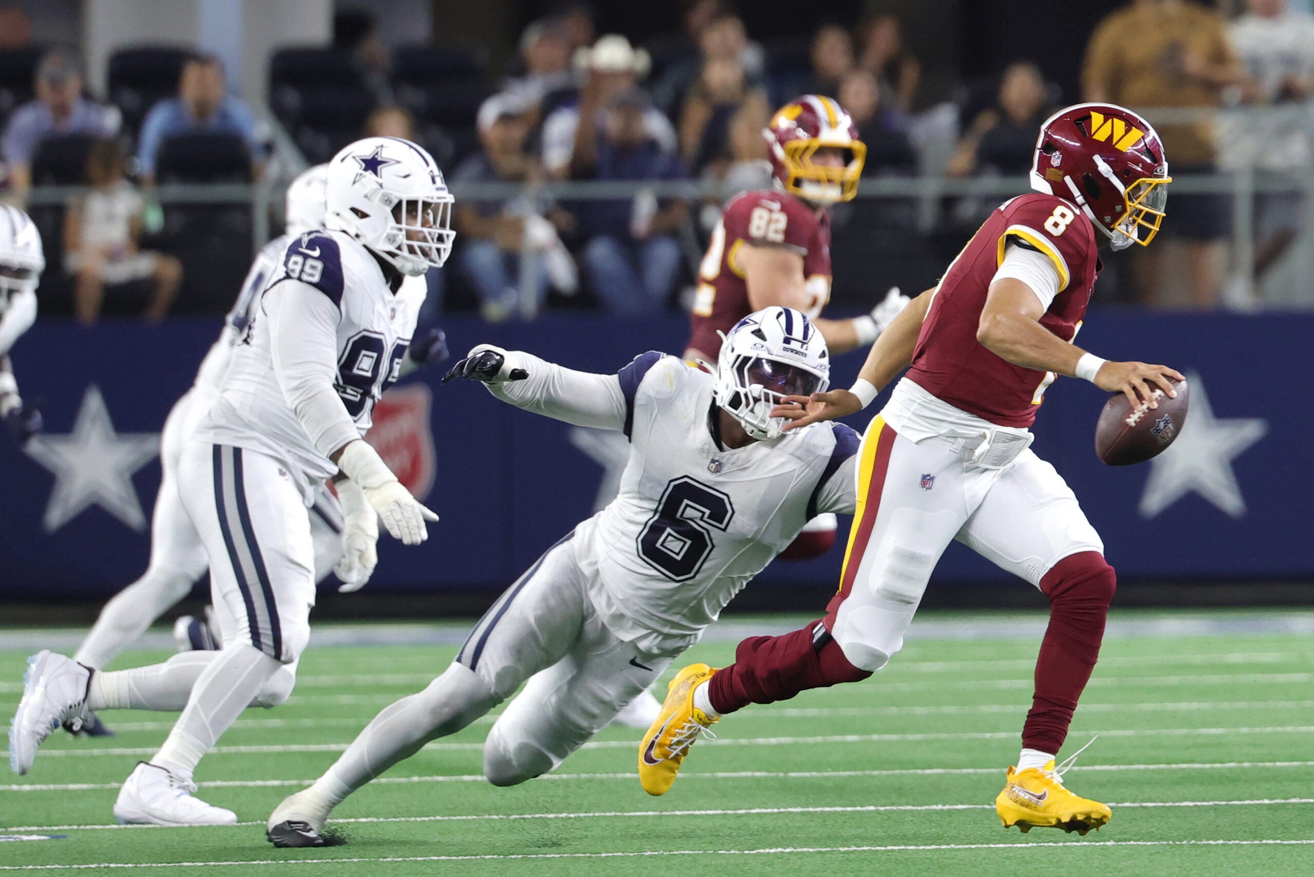 Sep 20, 2026; Arlington, Texas, USA; Washington Commanders quarterback Marcus Mariota (8) scrambles against Dallas Cowboys linebacker Donovan Ezeiruaku (6) during the fourth quarter at AT&T Stadium.