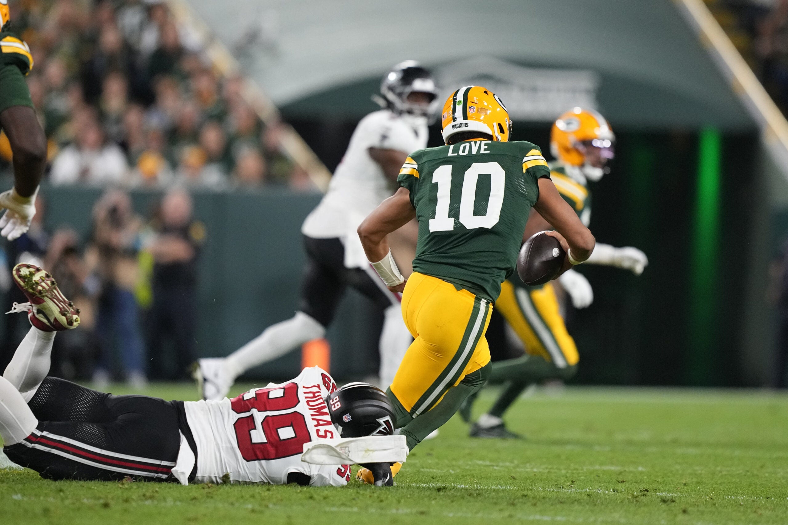 Sep 24, 2026; Green Bay, Wisconsin, USA; Atlanta Falcons defensive end Cameron Thomas (99) tackles Green Bay Packers quarterback Jordan Love (10) during the third quarter at Lambeau Field.