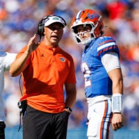 Sep 26, 2026; Gainesville, Florida, USA; Florida Gators head coach Jon Sumrall talks with quarterback Aaron Philo (12) during a timeout against the Mississippi Rebels during the first half at Ben Hill Griffin Stadium.