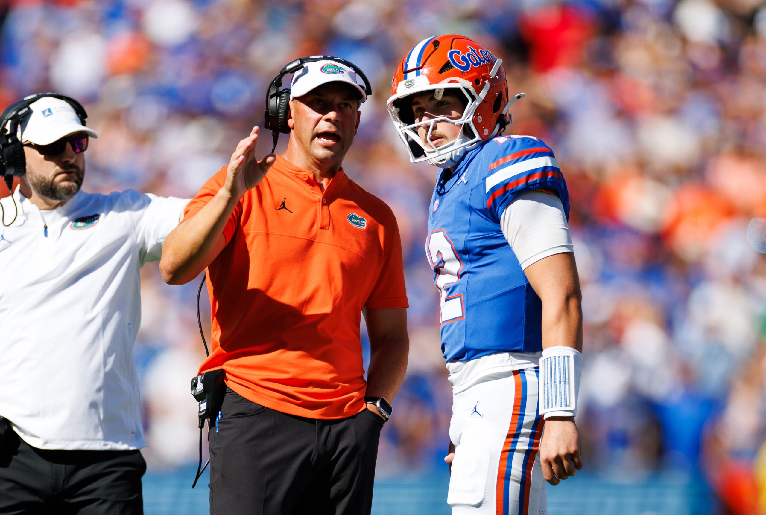 Sep 26, 2026; Gainesville, Florida, USA; Florida Gators head coach Jon Sumrall talks with quarterback Aaron Philo (12) during a timeout against the Mississippi Rebels during the first half at Ben Hill Griffin Stadium.