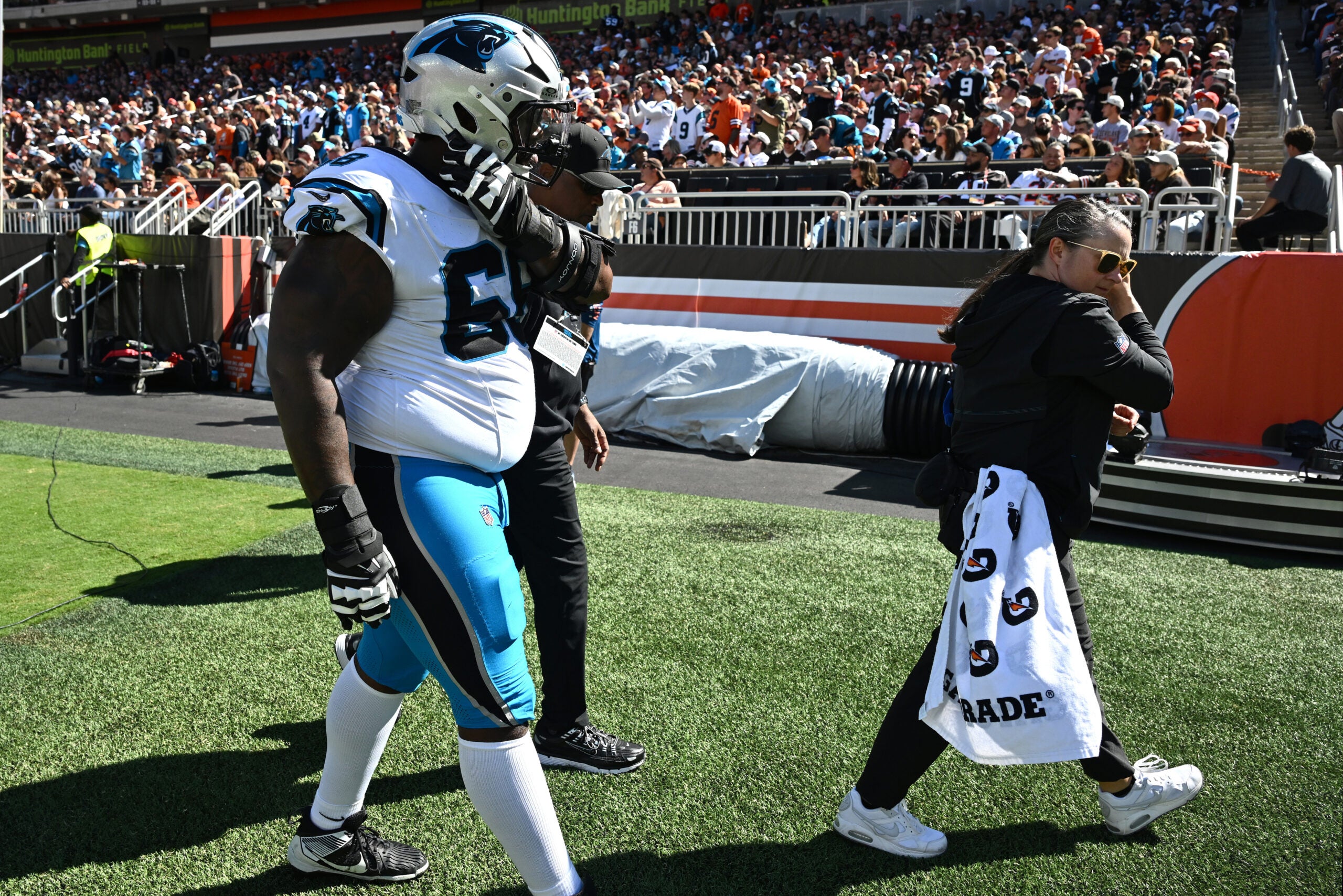 Sep 27, 2026; Cleveland, Ohio, USA; Carolina Panthers guard Damien Lewis (68) walks off the field with medical staff during the first half Cleveland Browns at Huntington Bank Field.