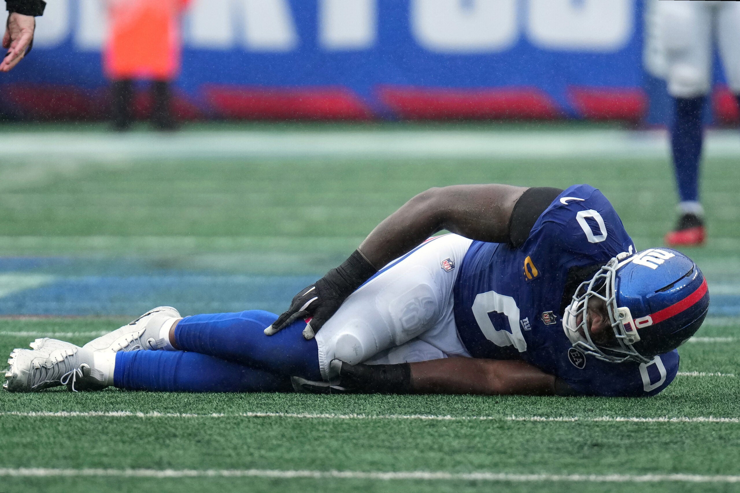 Sep 27, 2026; East Rutherford, New Jersey, USA; New York Giants linebacker Brian Burns (0) reacts after an apparent injury after a play against the Tennessee Titans during the fourth quarter at MetLife Stadium.