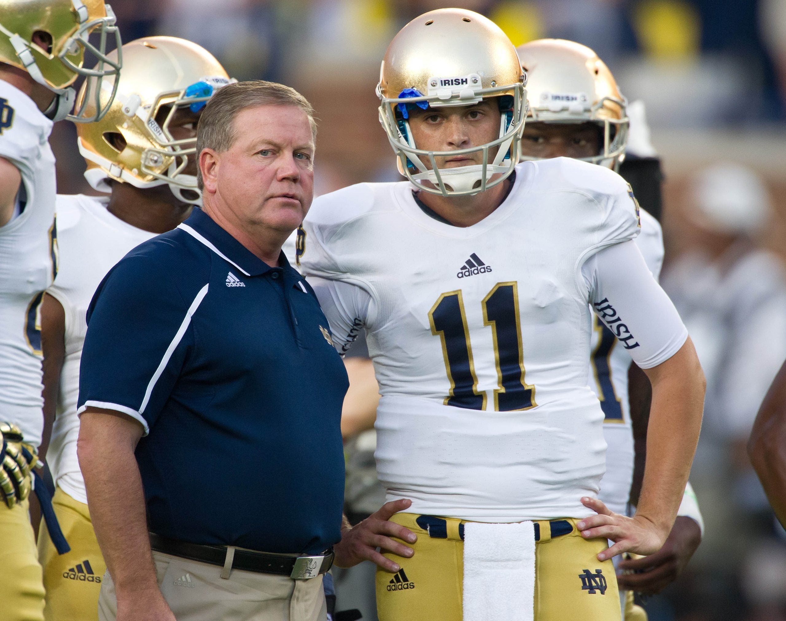 Sep 7, 2013; Ann Arbor, MI, USA; Notre Dame Fighting Irish head coach Brian Kelly talks with quarterback Tommy Rees (11) during warmups before the game against the Michigan Wolverines at Michigan Stadium. Michigan won 41-30.