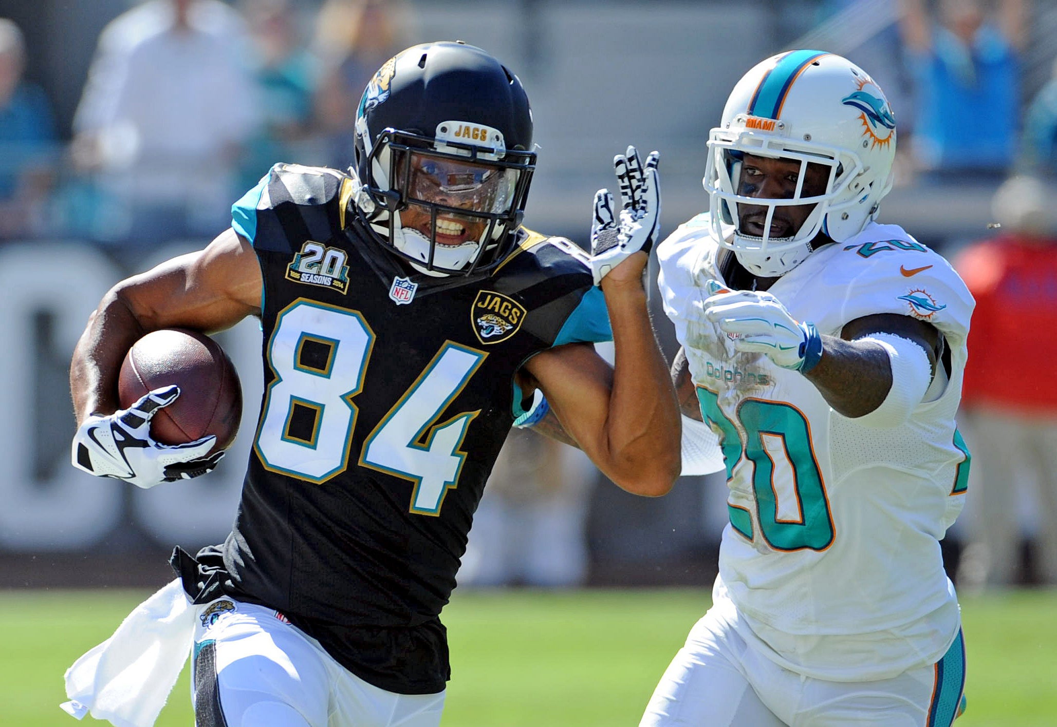 Oct 26, 2014; Jacksonville, FL, USA; Jacksonville Jaguars wide receiver Cecil Shorts III (84) runs the ball past Miami Dolphins safety Reshad Jones (20) during the first half of the game at EverBank Field.