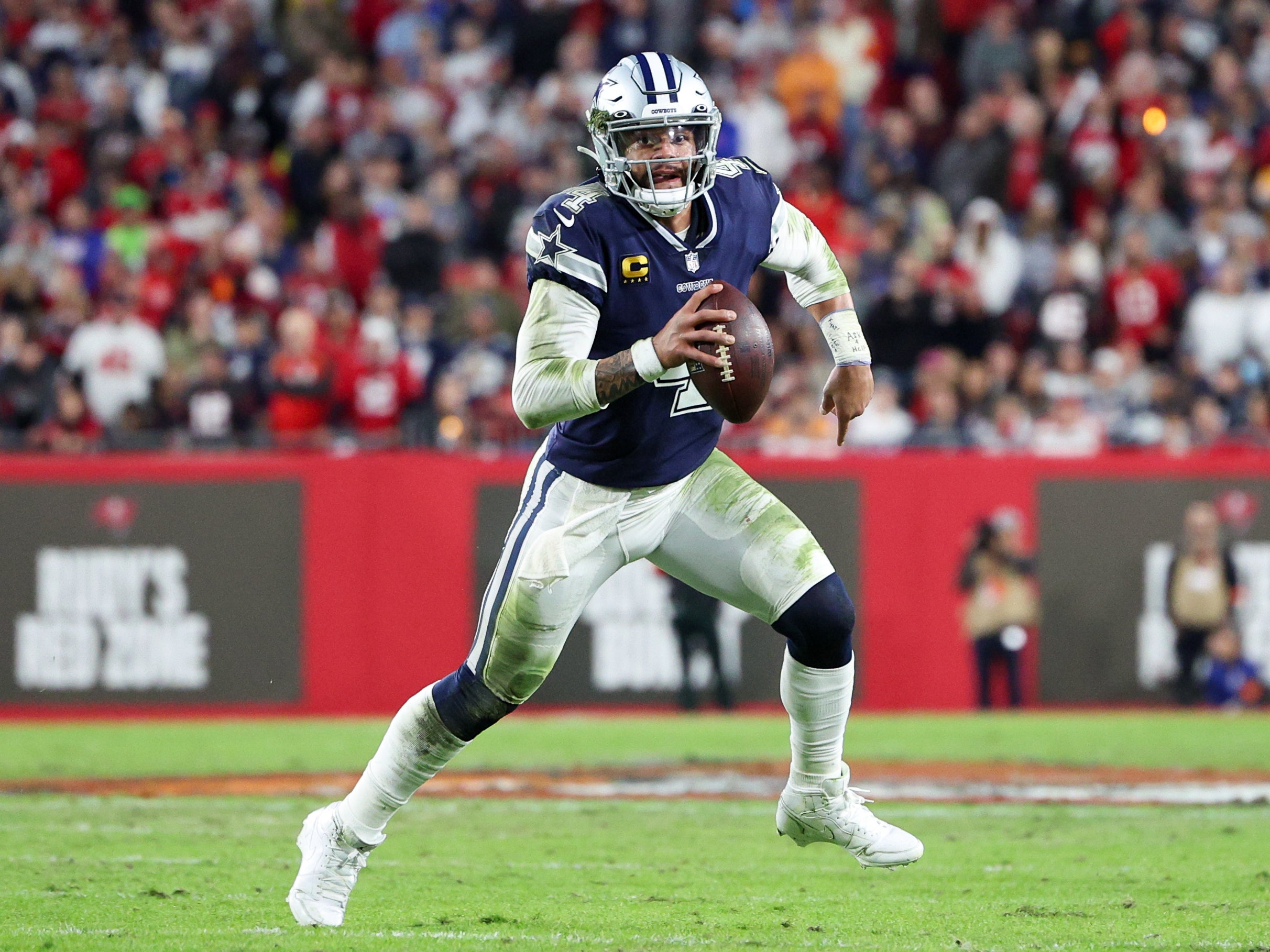 Jan 16, 2023; Tampa, Florida, USA; Dallas Cowboys quarterback Dak Prescott (4) runs with the ball against the Tampa Bay Buccaneers in the second quarter during a wild card game at Raymond James Stadium.