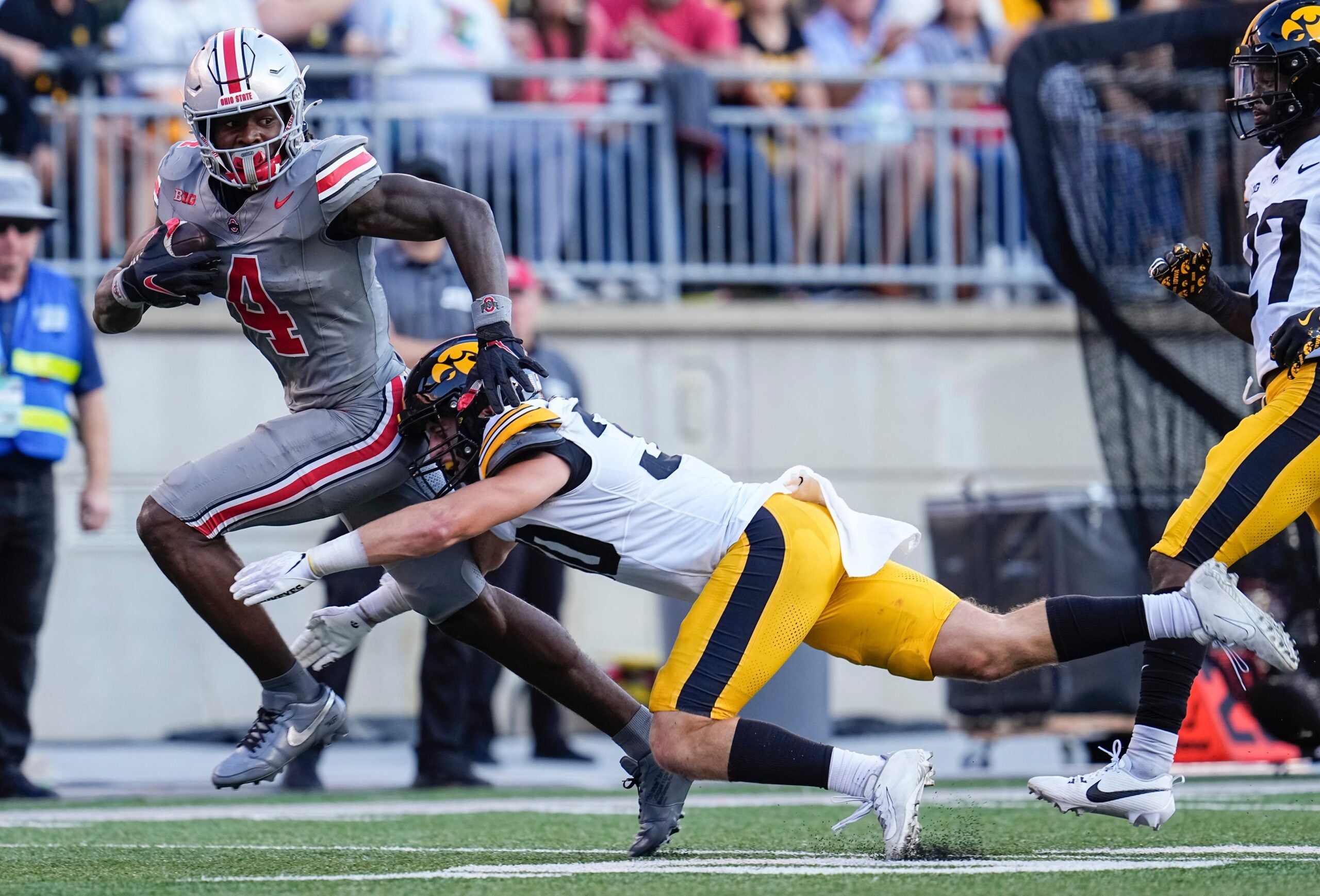 Oct 5, 2024; Columbus, OH, USA; Ohio State Buckeyes wide receiver Jeremiah Smith (4) runs past Iowa Hawkeyes defensive back Quinn Schulte (30) during the second half of the NCAA football game at Ohio Stadium. Ohio State won 35-7.