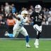 Jan 5, 2025; Paradise, Nevada, USA; Las Vegas Raiders quarterback Aidan O'Connell (12) carries the ball against Los Angeles Chargers linebacker Khalil Mack (52) in the second half at Allegiant Stadium.