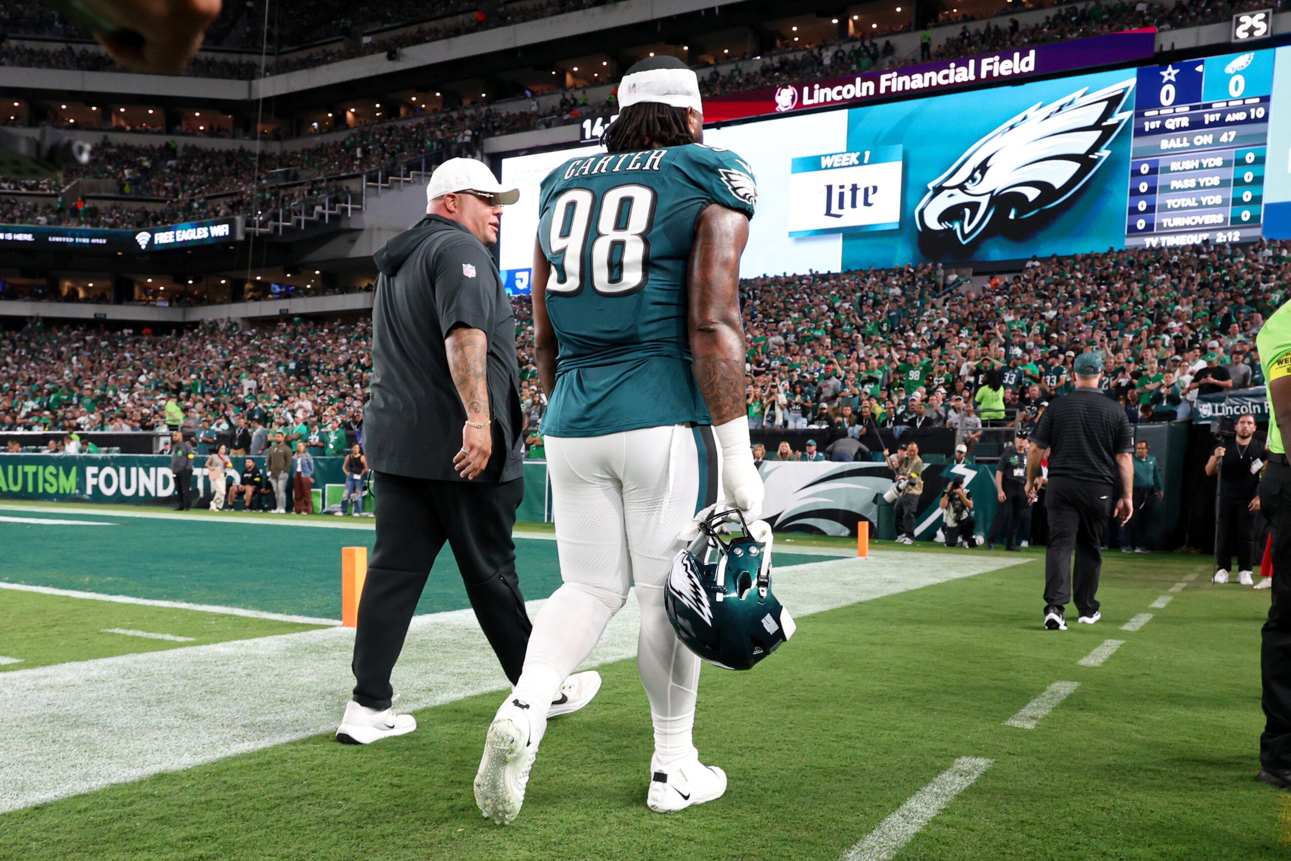 Sep 4, 2025; Philadelphia, Pennsylvania, USA; Philadelphia Eagles defensive tackle Jalen Carter (98) walks off the field with Eagles chief security officer Dom DiSandro (L) after being ejected from the game against the Dallas Cowboys at Lincoln Financial Field.