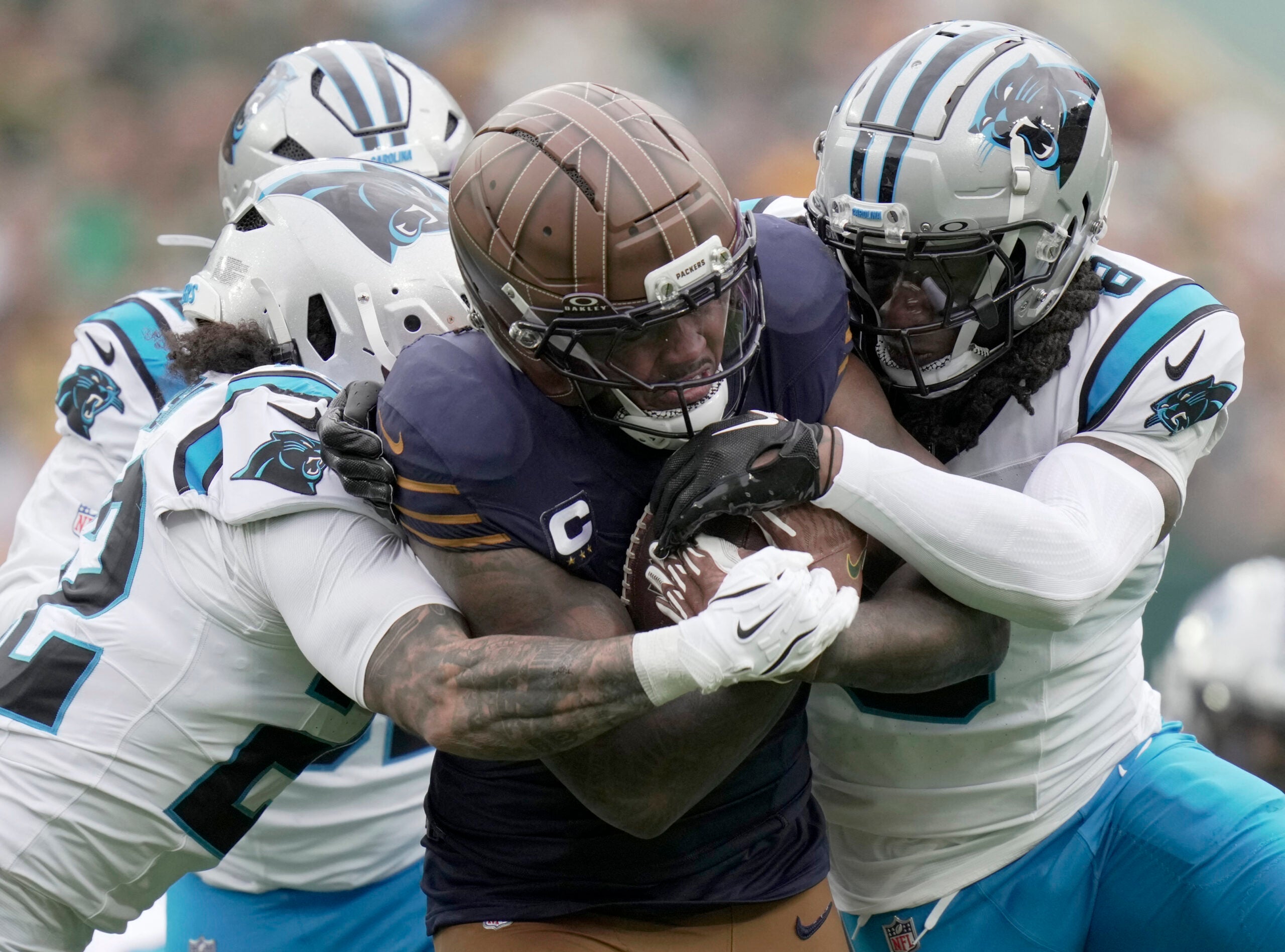 Nov 2, 2025; Green Bay, Wisconsin, USA; Green Bay Packers running back Josh Jacobs (8) runs for 18 yards before being tackled by Carolina Panthers safety Lathan Ransom (22) and cornerback Jaycee Horn (8) during the first quarter of their game at Lambeau Field.