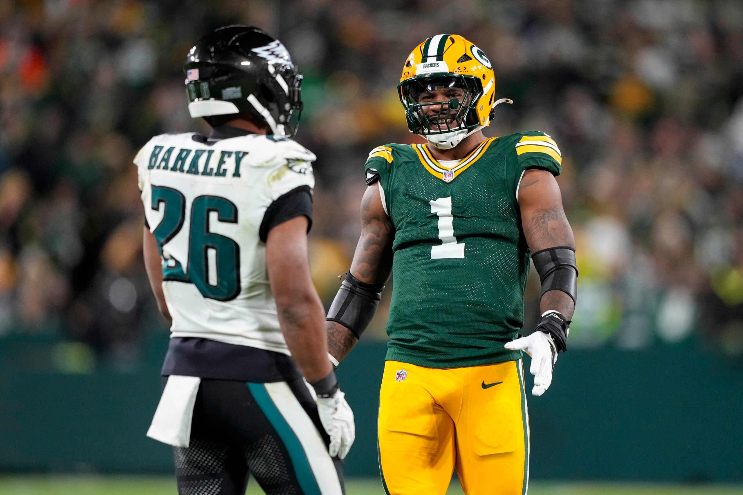 Nov 10, 2025; Green Bay, Wisconsin, USA; Green Bay Packers defensive end Micah Parsons (1) talks with running back Saquon Barkley (26) during the game at Lambeau Field.