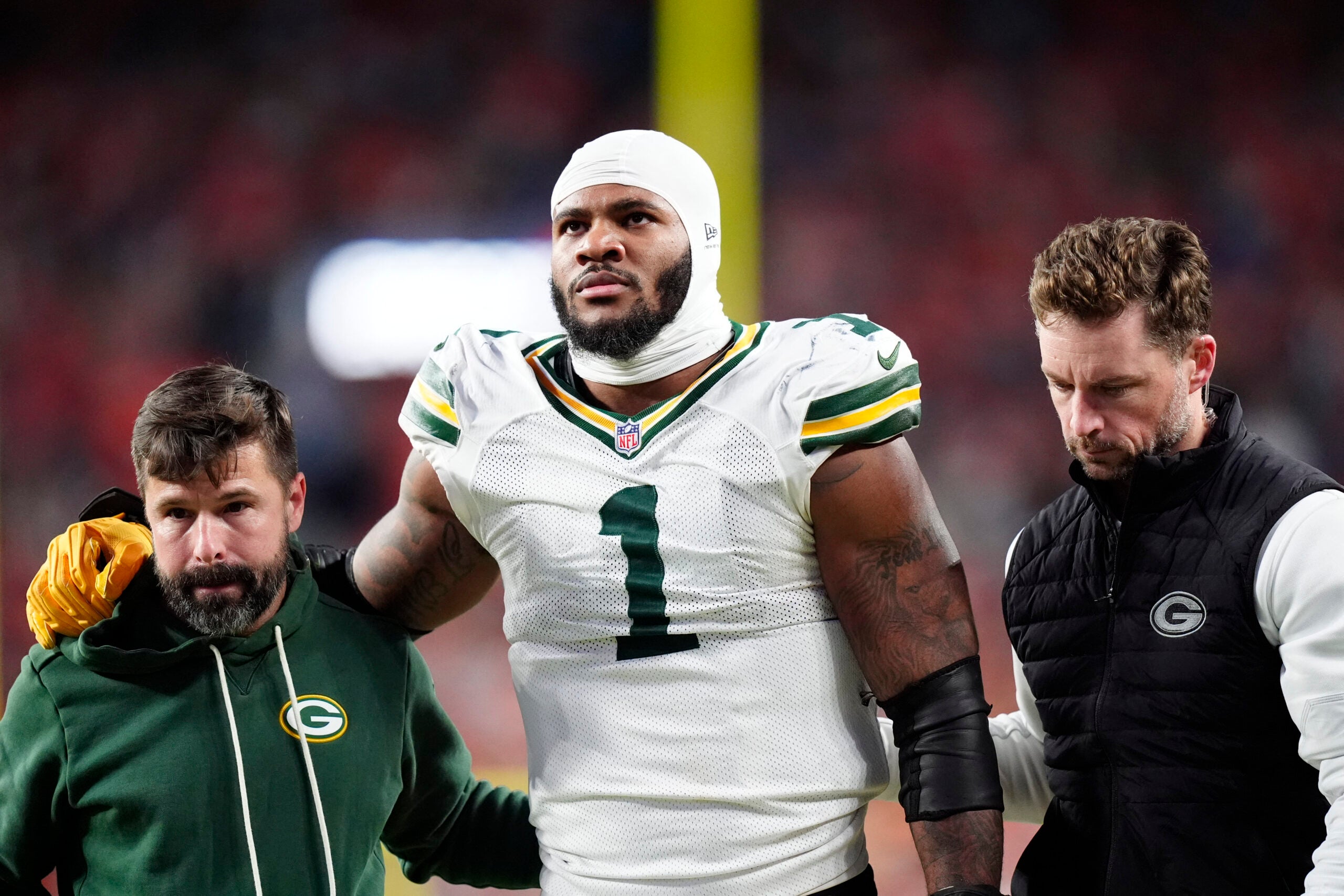 Dec 14, 2025; Denver, Colorado, USA; Green Bay Packers defensive end Micah Parsons (1) walks off the field with help from medical personnel following an injury during the third quarter against the Denver Broncos at Empower Field at Mile High.