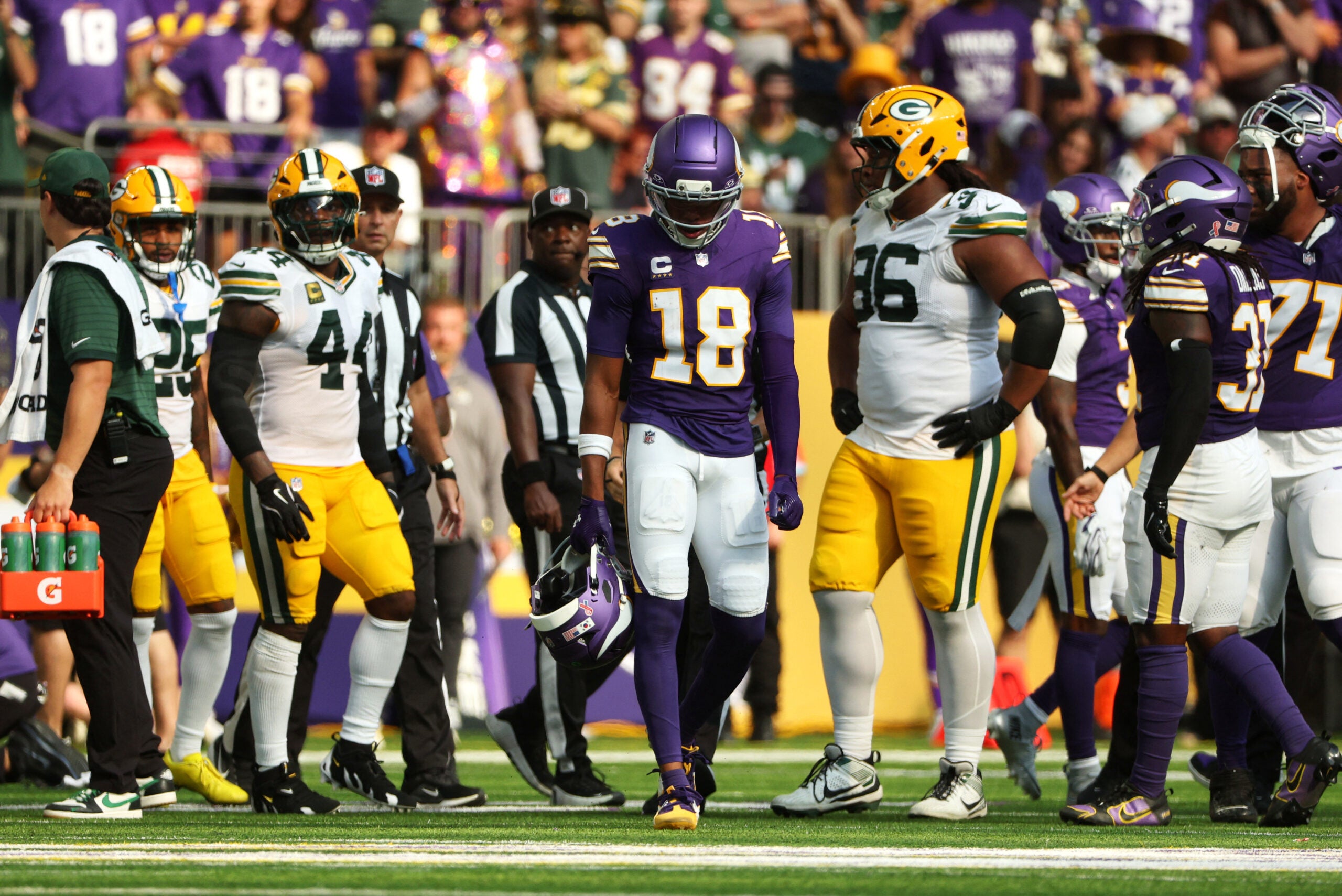 Sep 13, 2026; Minneapolis, Minnesota, USA; Minnesota Vikings wide receiver Justin Jefferson (18) carries Minnesota Vikings quarterback Kyler Murray (1) helmet off the field after a play during the first half against the Green Bay Packers at U.S. Bank Stadium.