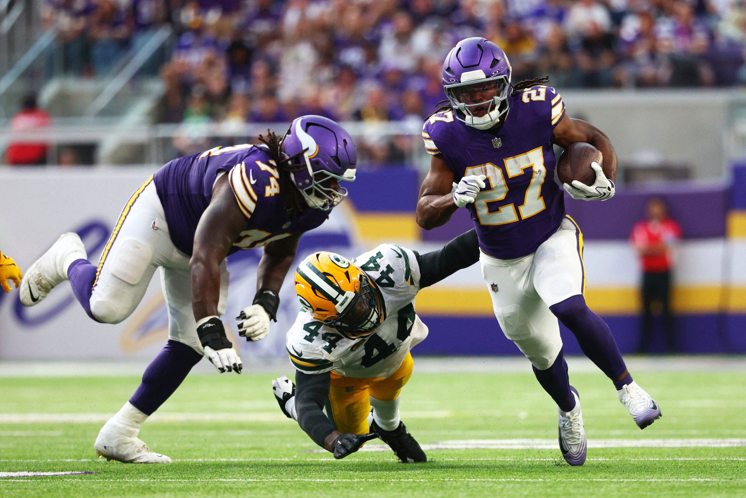 Sep 13, 2026; Minneapolis, Minnesota, USA; Minnesota Vikings running back Jordan Mason (27) runs the ball against Green Bay Packers linebacker Zaire Franklin (44) during the second half at U.S. Bank Stadium.