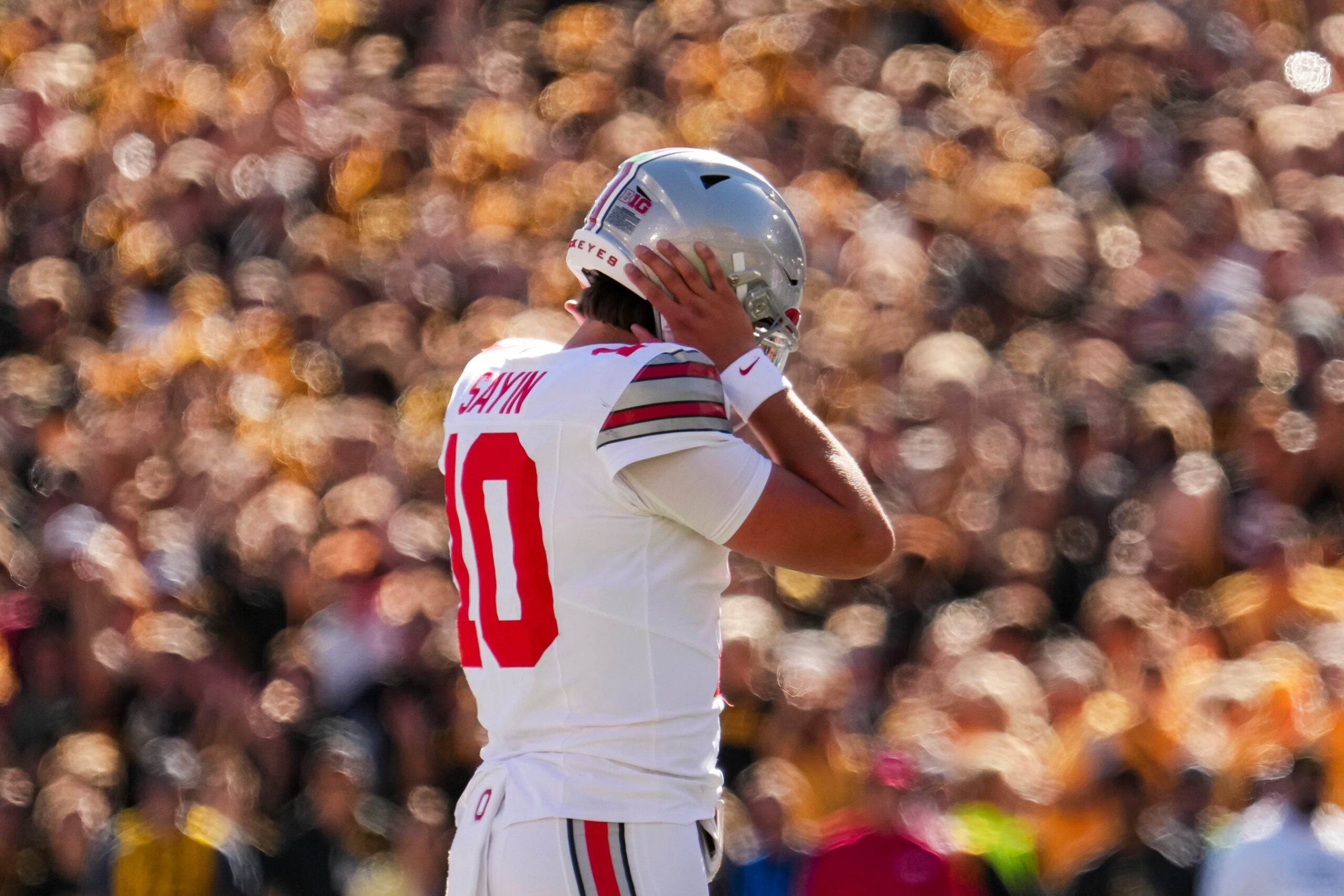 Ohio State Buckeyes quarterback Julian Sayin (10) covers his ears to hear the play call during the NCAA football game against the Iowa Hawkeyes at Kinnick Stadium in Iowa City on Oct. 3, 2026.