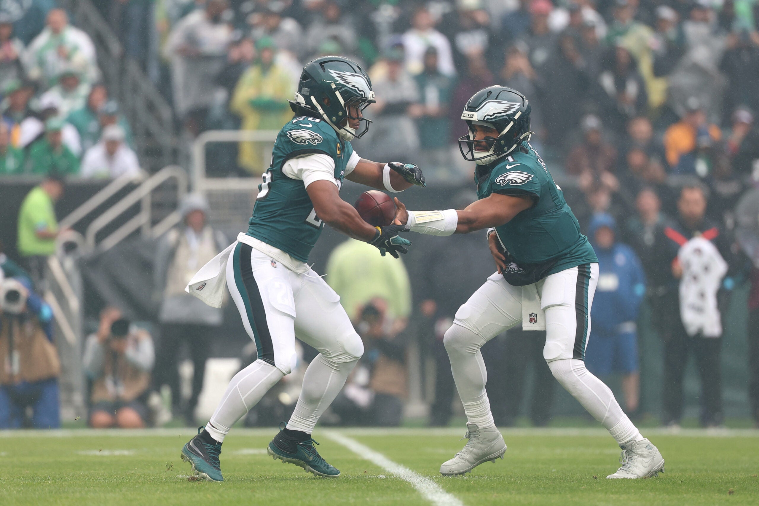 Oct 4, 2026; Philadelphia, Pennsylvania, USA; Philadelphia Eagles quarterback Jalen Hurts (1) hands the ball off to running back Saquon Barkley (26) against the Los Angeles Rams during the first quarter at Lincoln Financial Field.
