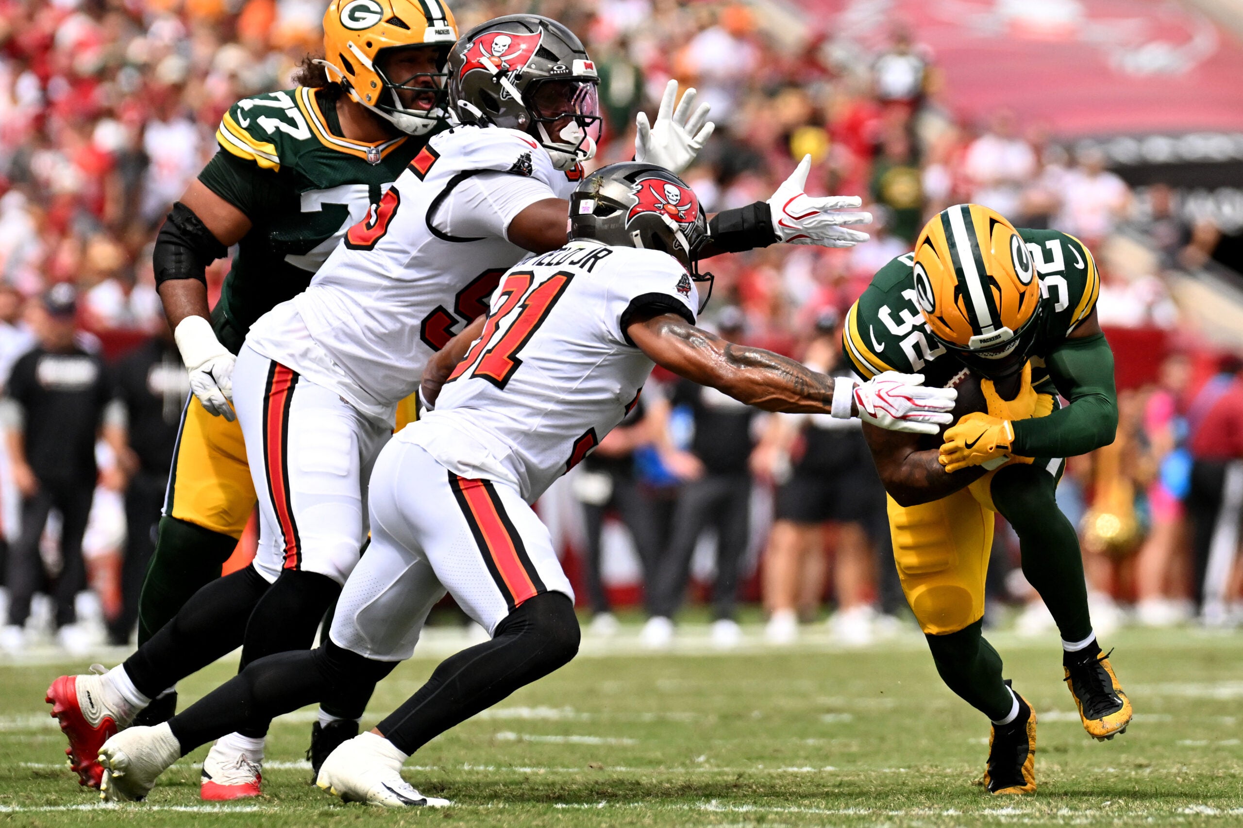 Oct 4, 2026; Tampa, Florida, USA; Tampa Bay Buccaneers safety Antoine Winfield Jr. (31) tackles Green Bay Packers running back MarShawn Lloyd (32) at Raymond James Stadium.