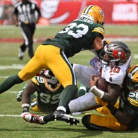 Oct 4, 2026; Tampa, Florida, USA; Green Bay Packers safety Evan Williams (33) and linebacker Edgerrin Cooper (56) tackles Tampa Bay Buccaneers quarterback Jalon Daniels (10) during the game at Raymond James Stadium.