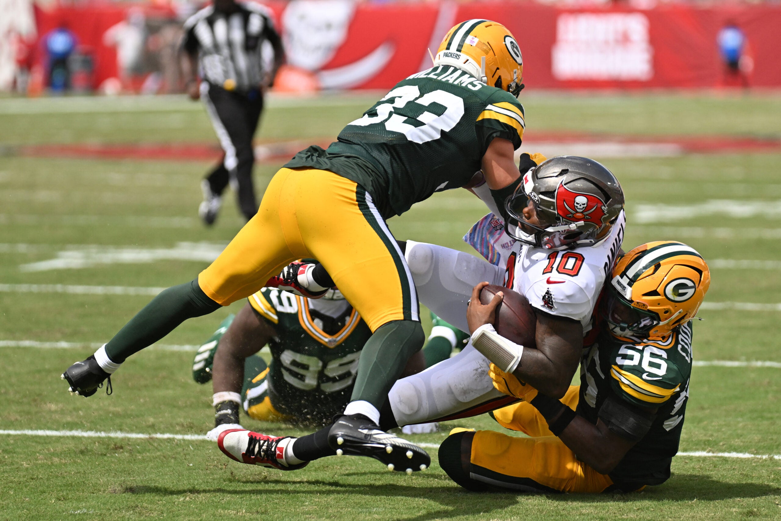 Oct 4, 2026; Tampa, Florida, USA; Green Bay Packers safety Evan Williams (33) and linebacker Edgerrin Cooper (56) tackles Tampa Bay Buccaneers quarterback Jalon Daniels (10) during the game at Raymond James Stadium.