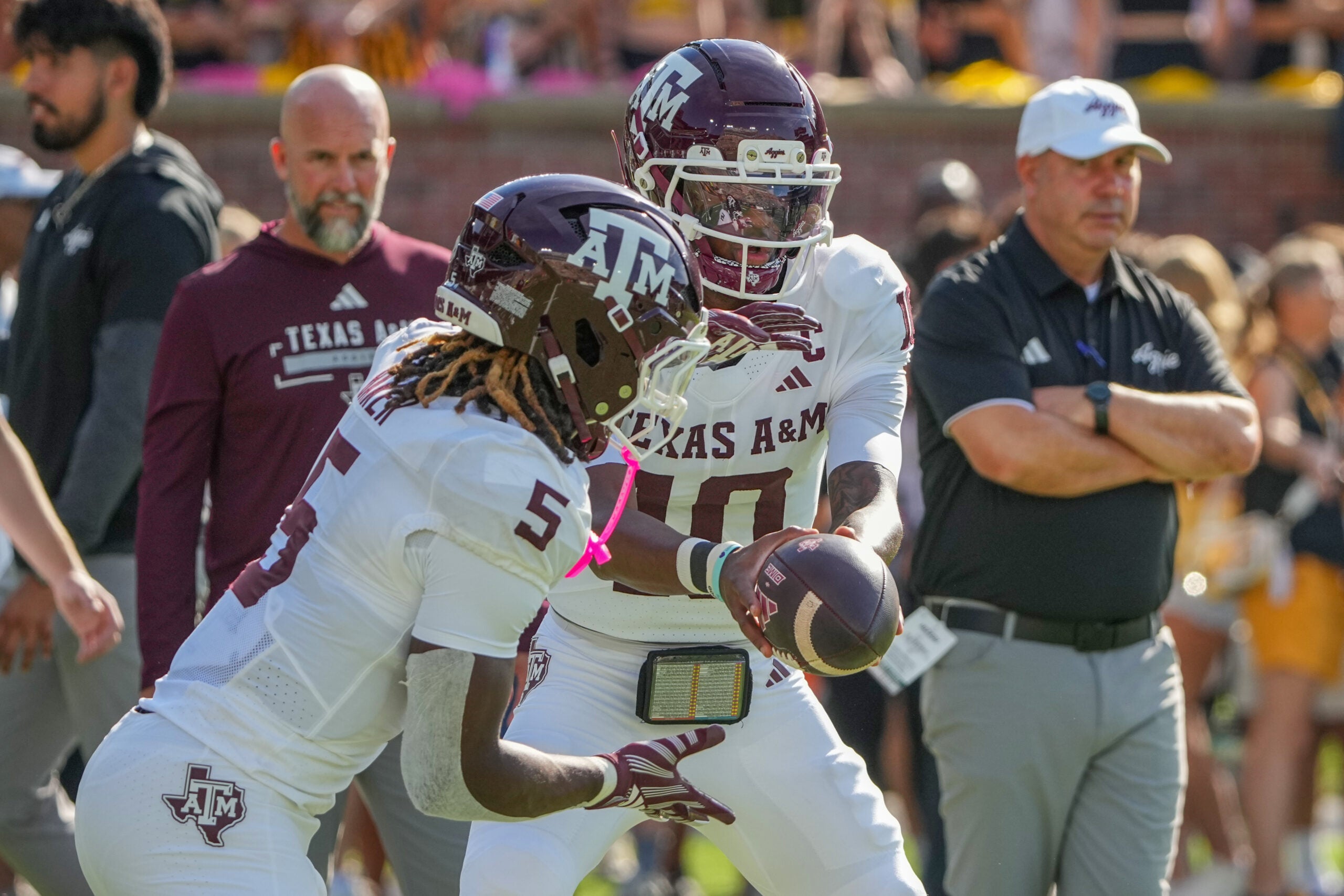 Oct 10, 2026; Columbia, Missouri, USA; Texas A&M Aggies quarterback Marcel Reed (10) hands off to running back Carsyn Baker (5) against the Missouri Tigers prior to a game at Faurot Field at Memorial Stadium.