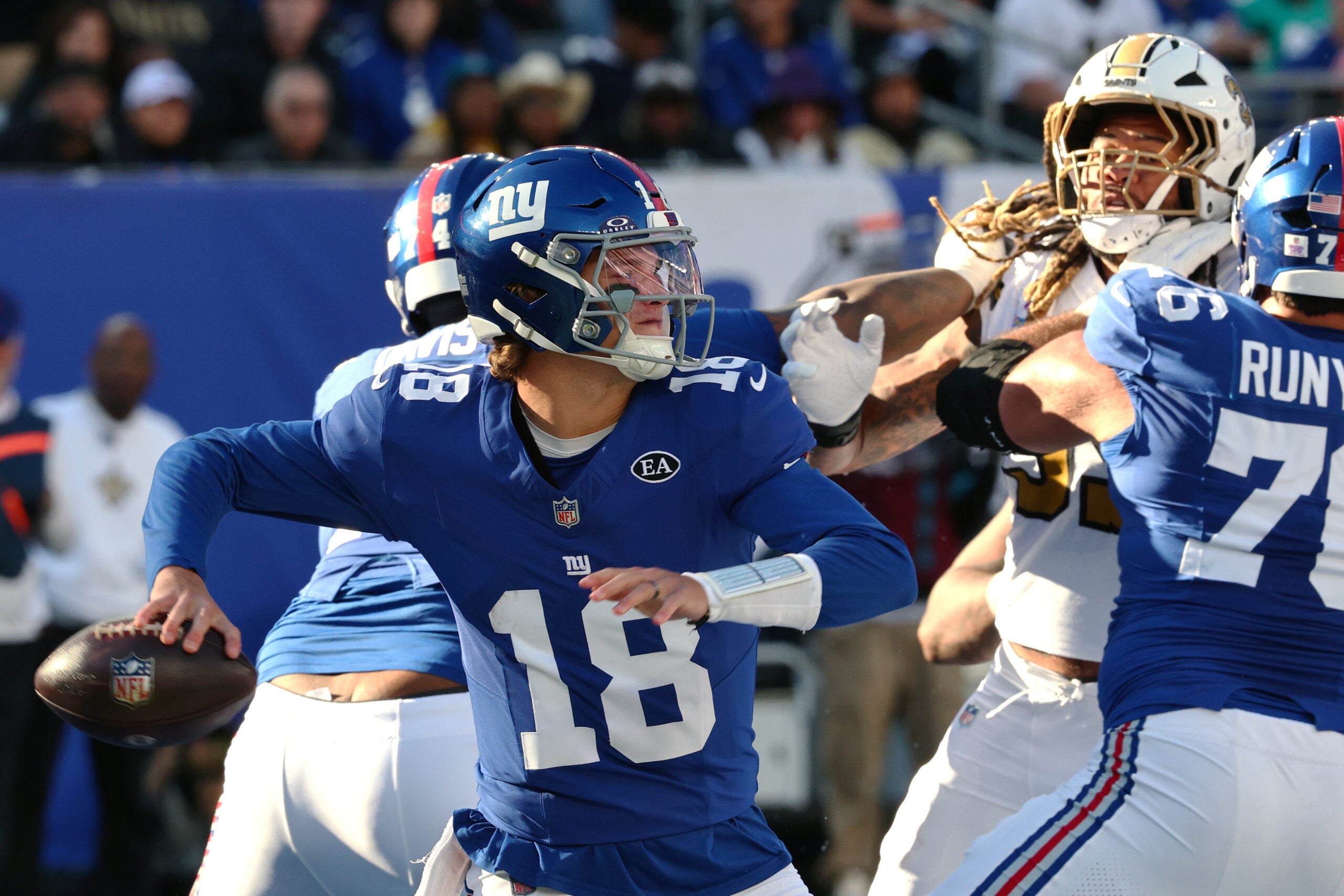 Oct 18, 2026; East Rutherford, New Jersey, USA; New York Giants quarterback J.J. McCarthy (18) throws a pass against New Orleans Saints defensive end Chase Young (99) during the fourth quarter at MetLife Stadium.