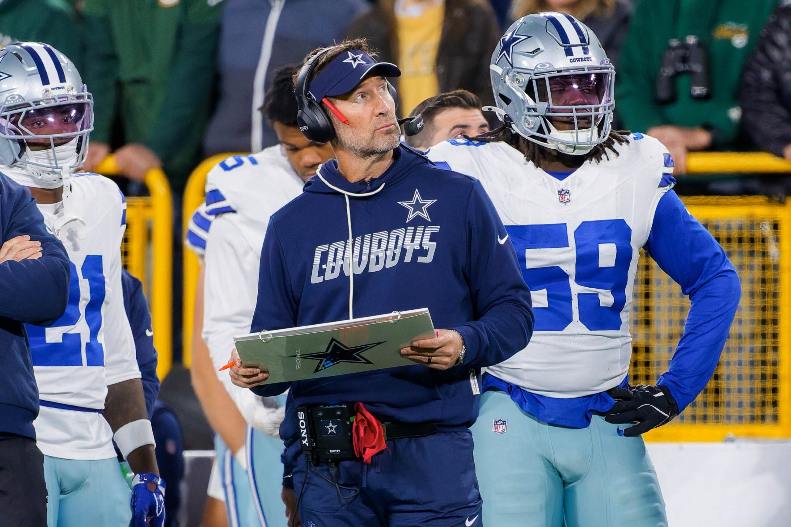 Oct 18, 2026; Green Bay, Wisconsin, USA; Dallas Cowboys head coach Brian Schottenheimer watches the field alongside Dallas Cowboys Tyrus Wheat (59) at Lambeau Field.