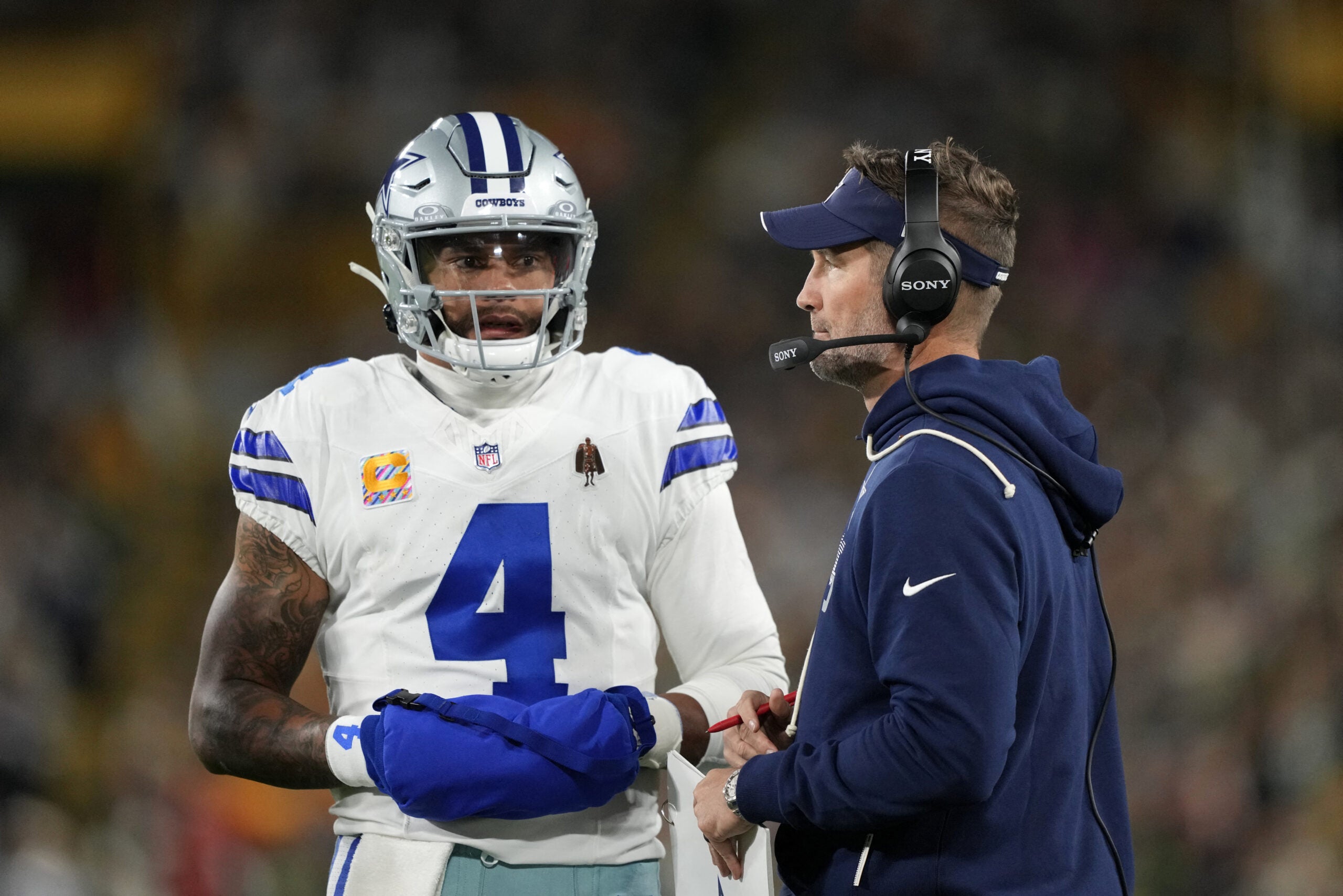 Oct 18, 2026; Green Bay, Wisconsin, USA; Dallas Cowboys quarterback Dak Prescott (4) talks with Dallas Cowboys head coach Brian Schottenheimer talk during the first quarter against the Green Bay Packers at Lambeau Field.