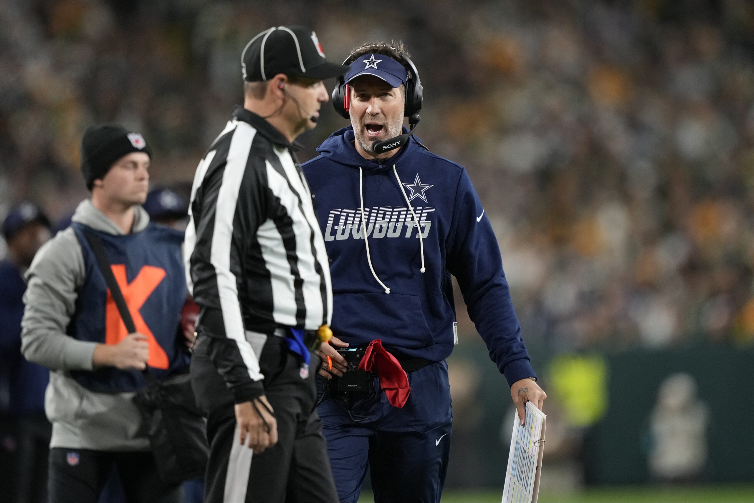 Oct 18, 2026; Green Bay, Wisconsin, USA; Dallas Cowboys head coach Brian Schottenheimer talks with an official during the first half of the game against the Green Bay Packers at Lambeau Field.