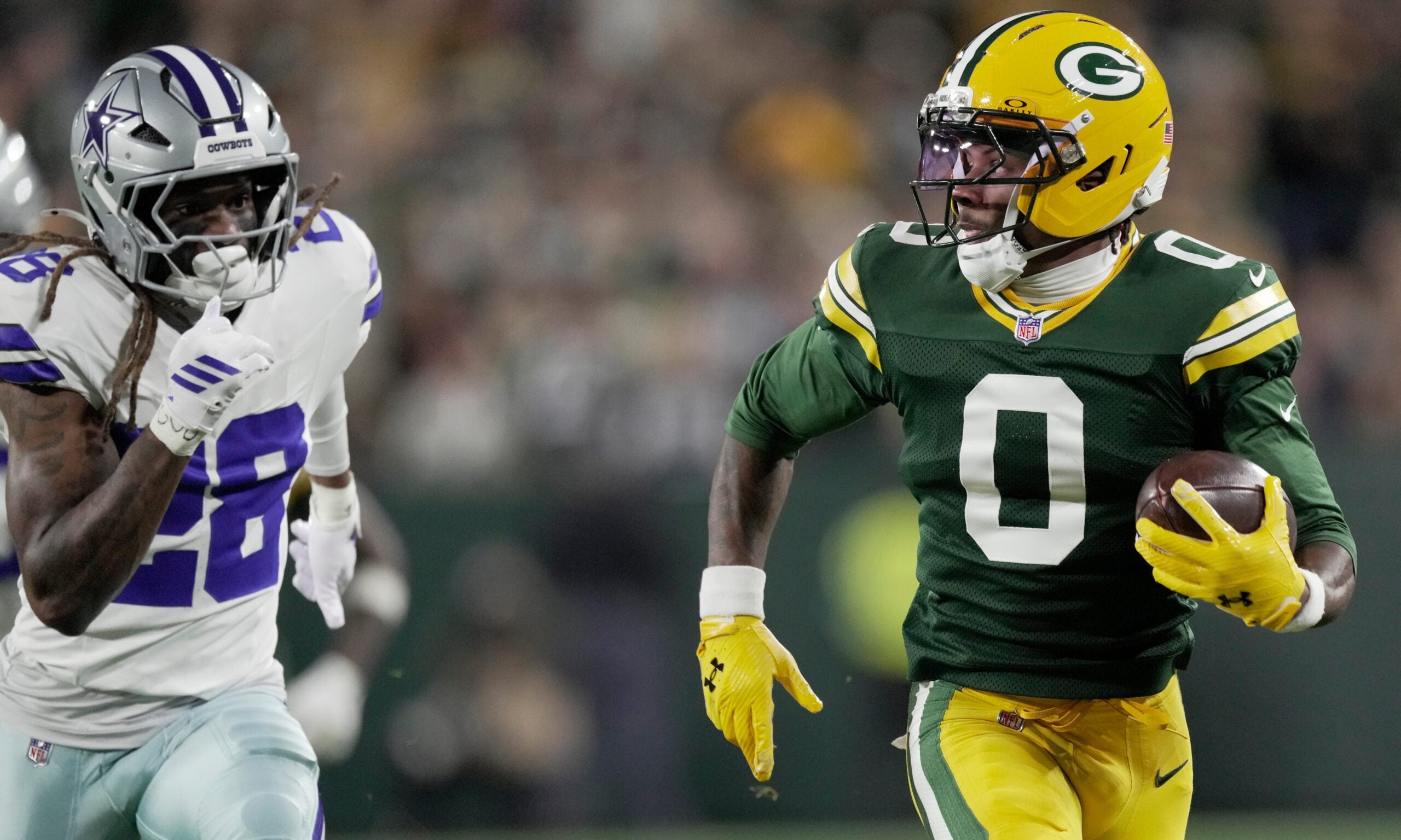 Green Bay Packers wide receiver Matthew Golden (0) is pursued by Dallas Cowboys' Shavon Revel Jr. (28) on a 37-yard reception during the first quarter of their game Sunday, Oct. 18, 2026 at Lambeau Field in Green Bay, Wisconsin.