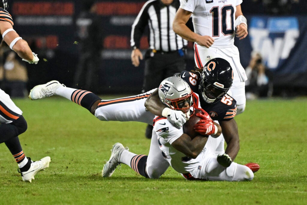 Oct 22, 2026; Chicago, Illinois, USA; New England Patriots running back Treveyon Henderson (32) is tackled by Chicago Bears defensive end Jamree Kromah (59) during the second half at Soldier Field.