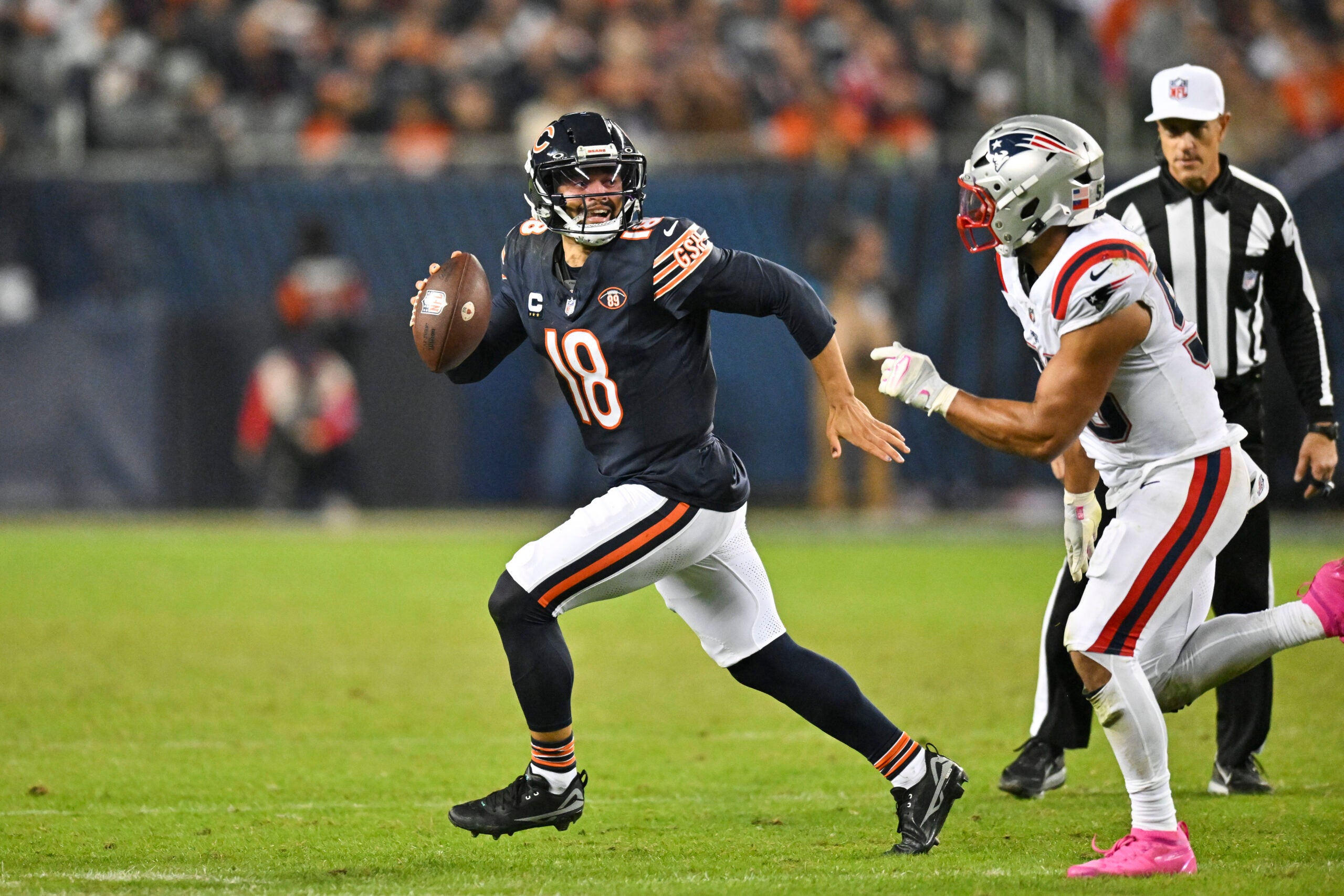 Oct 22, 2026; Chicago, Illinois, USA; Chicago Bears quarterback Caleb Williams (18) scrambles against New England Patriots linebacker Christian Elliss (53) during the fourth quarter at Soldier Field.