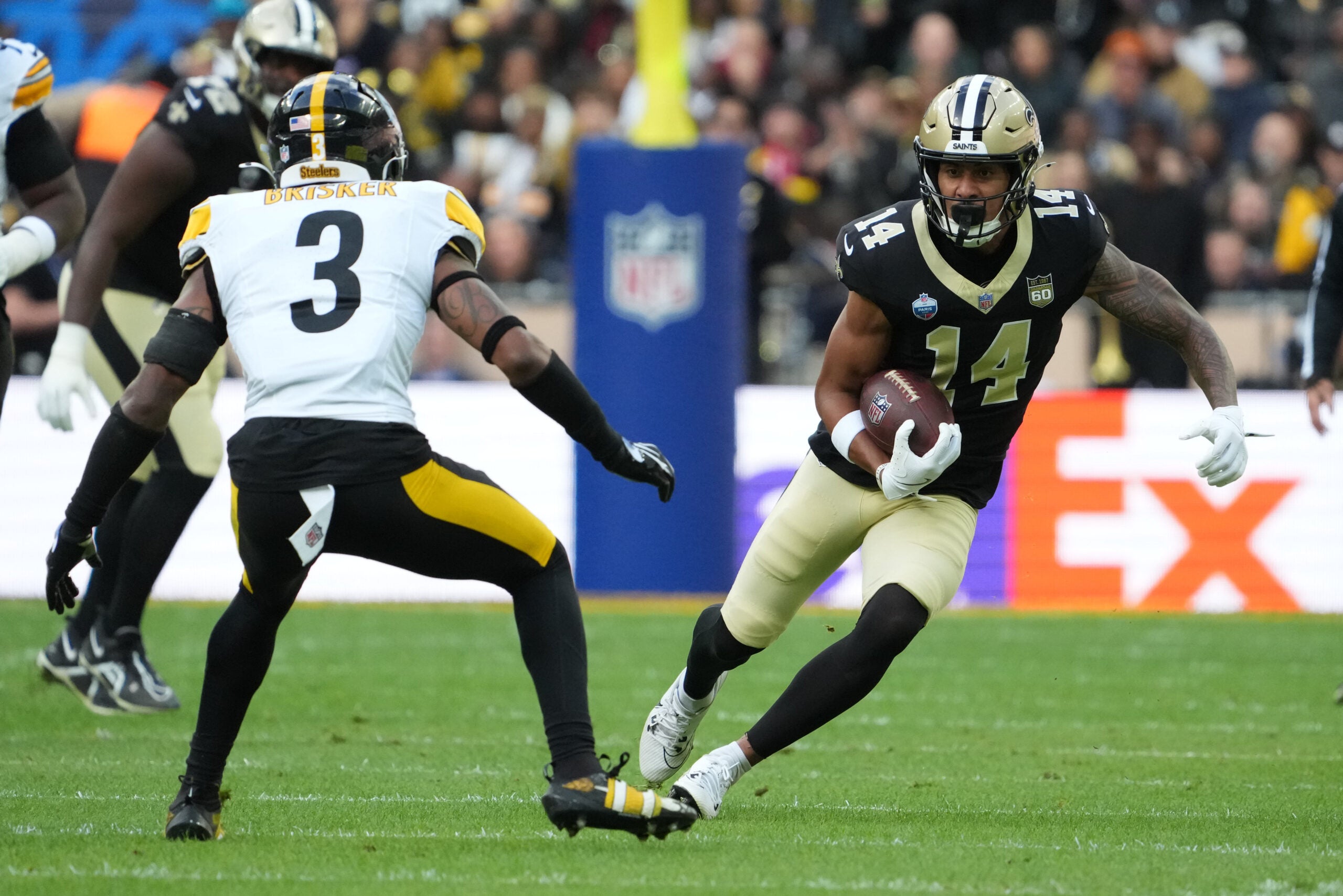 Oct 25, 2026; Paris, FRA; New Orleans Saints wide receiver Devaughn Vele (14) runs after the catch as Pittsburgh Steelers safety Jaquan Brisker (3) defends during the first quarter at Stade de France Stadium.