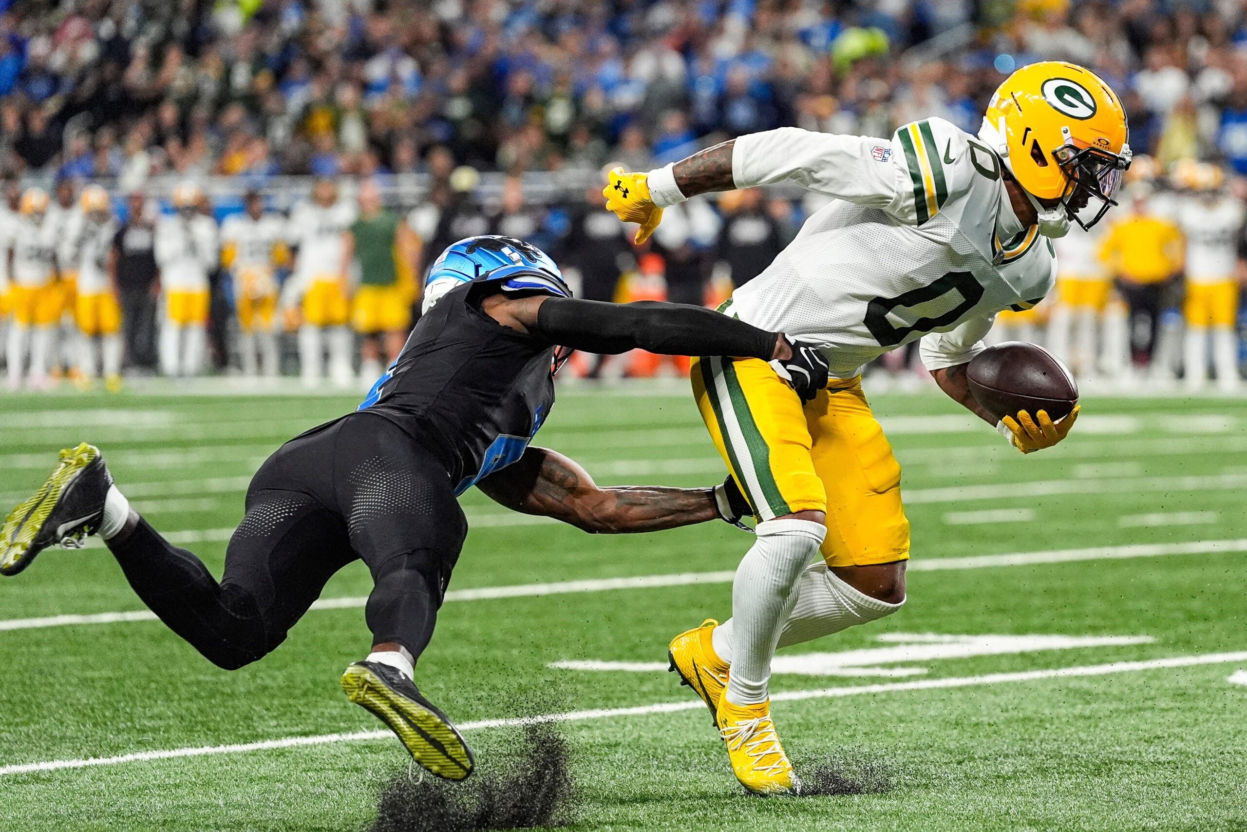 Detroit Lions cornerback D.J. Reed (4) tackles Green Bay Packers wide receiver Matthew Golden (0) during the first half at Ford Field in Detroit on Sunday, Oct. 25, 2026.