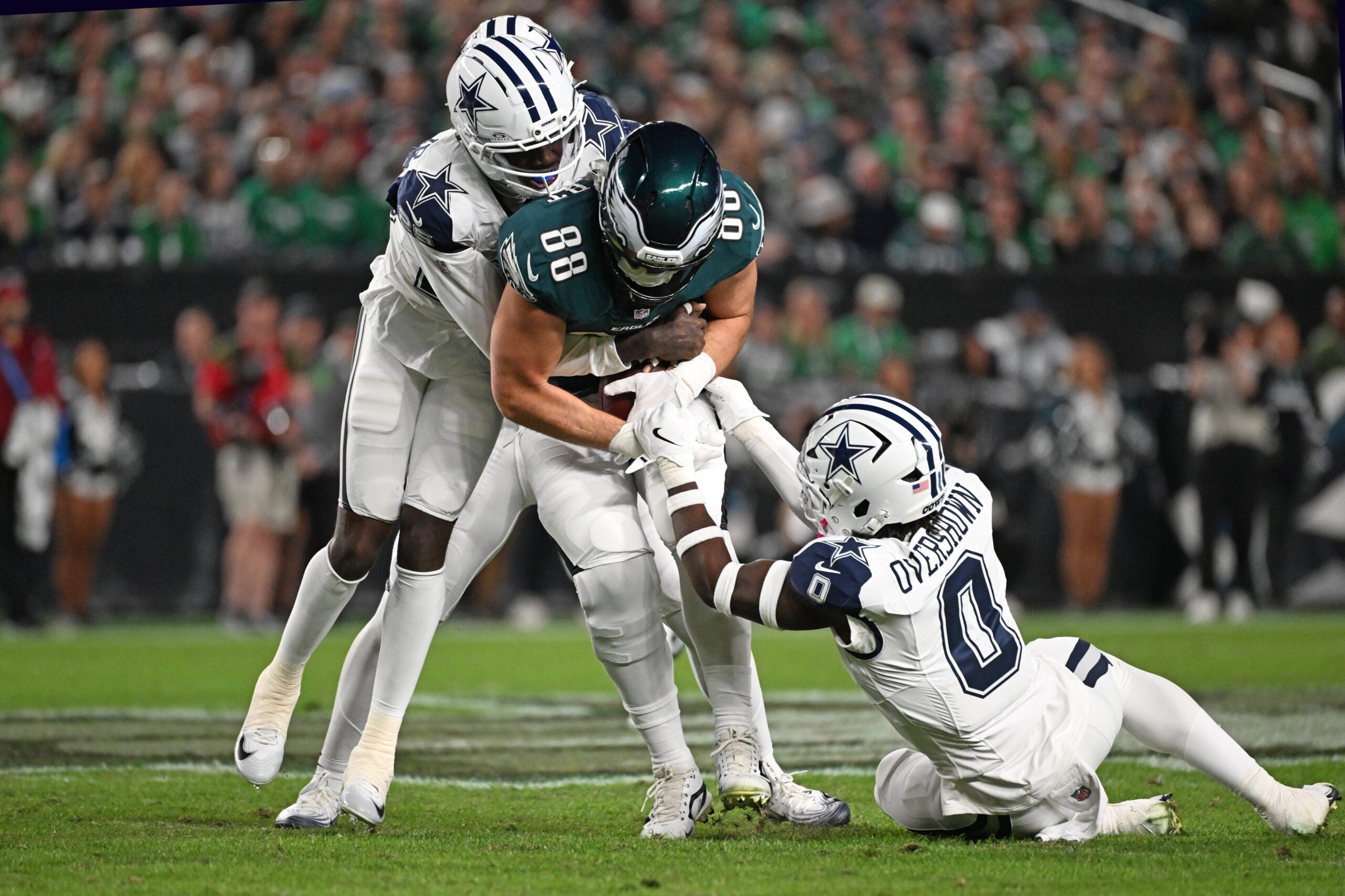 Oct 26, 2026; Philadelphia, Pennsylvania, USA; Philadelphia Eagles tight end Dallas Goedert (88) is tackled by Dallas Cowboys cornerback Joey Porter Jr. (25) and linebacker DeMarvion Overshown (0) during the first half at Lincoln Financial Field.
